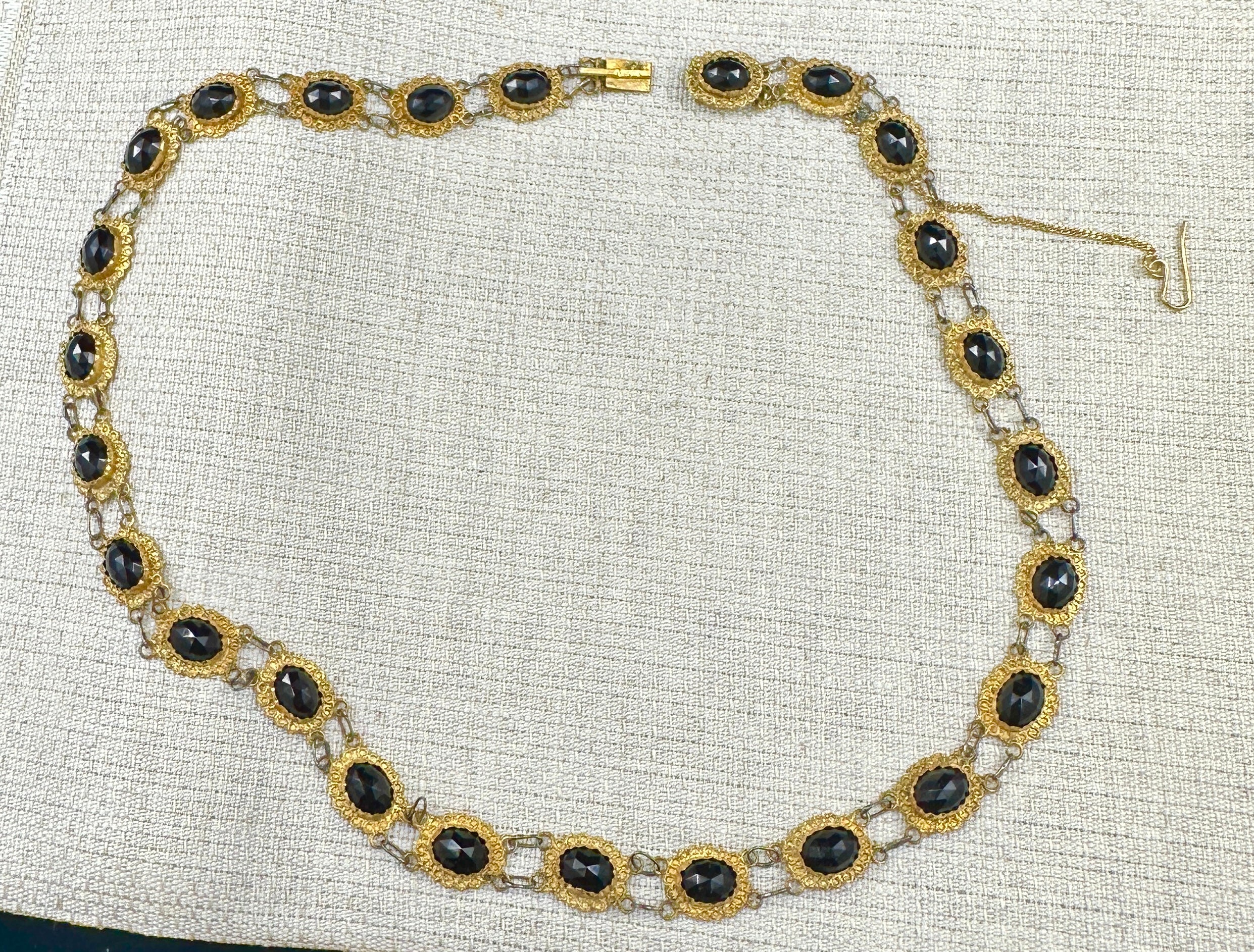 Concediti una rarissima e precoce collana di granati olandese in stile georgiano-vittoriano riccamente decorata con 25 maglie in oro a 12-14 carati.  Su ogni maglia è incastonato uno splendido granato rosso ovale sfaccettato.  I granati sono di un
