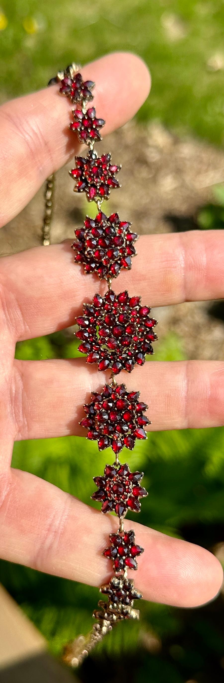THIS IS AN ABSOLUTELY GORGEOUS 19 INCH ANTIQUE VICTORIAN BELLE EPOQUE BOHEMIAN GARNET NECKLACE WITH FLOWER FLORETS IN THE CHAIN OF SUPERB DEEP RED WINE GARNETS WITH A FLOWER MOTIF CLASP OF THE HIGHEST QUALITY DATING TO CIRCA 1850-1880. THE NECKLACE