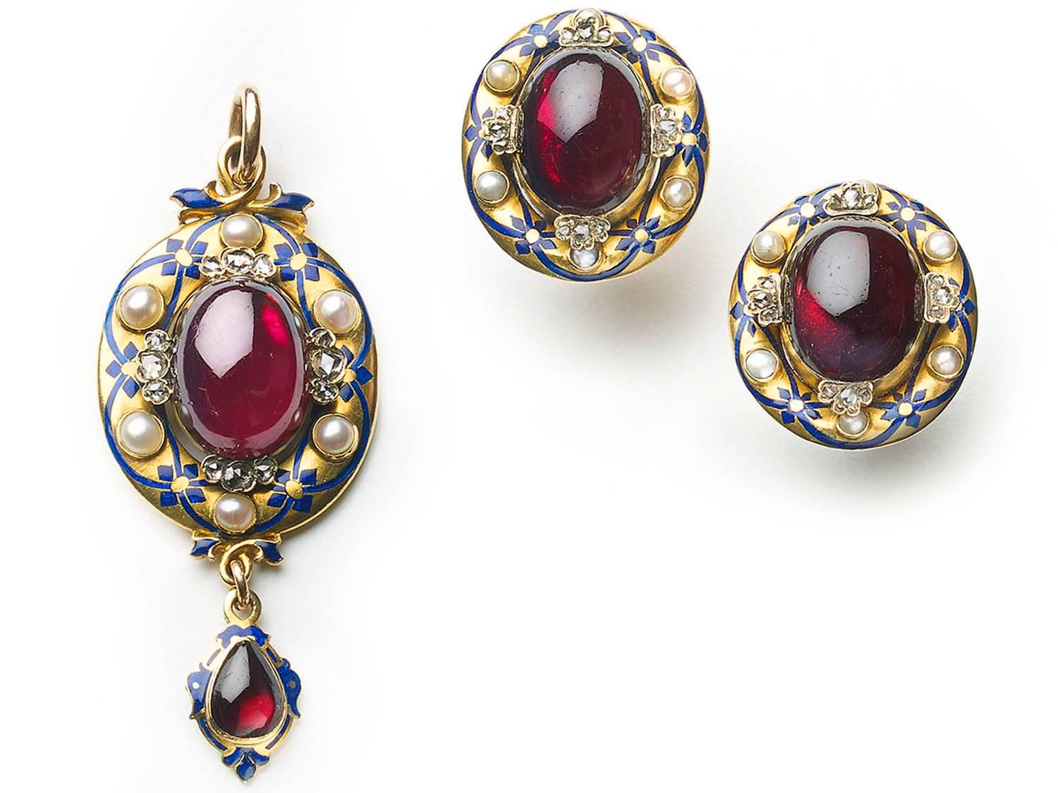 A Holbeinesque style Victorian pendant and earrings suite, set with cabochon garnets and rose-cut diamonds, with gold surrounds, decorated with blue, champlevé enamelled garlands, set with natural half pearls. The backs are engraved with foliage and