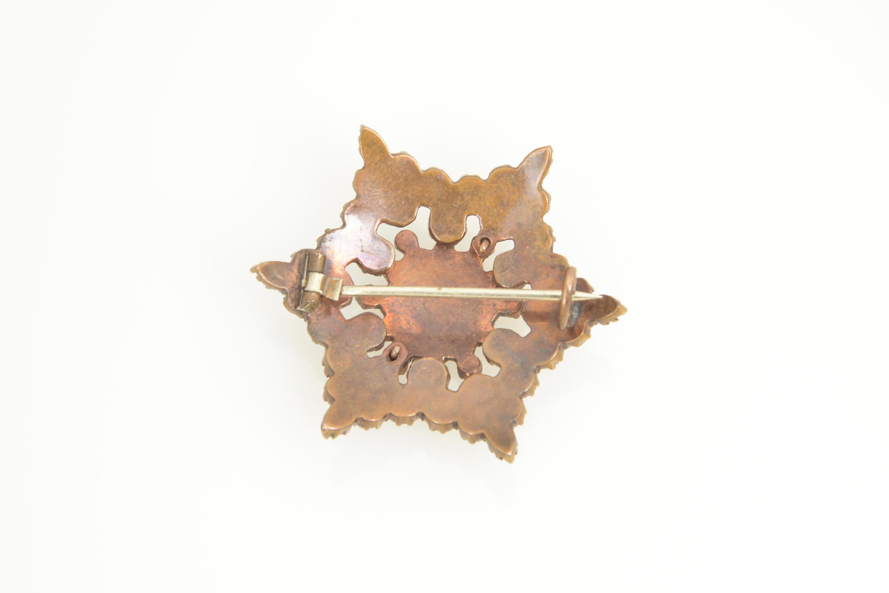 Victorian garnet six-point star brooch set in base metal.
