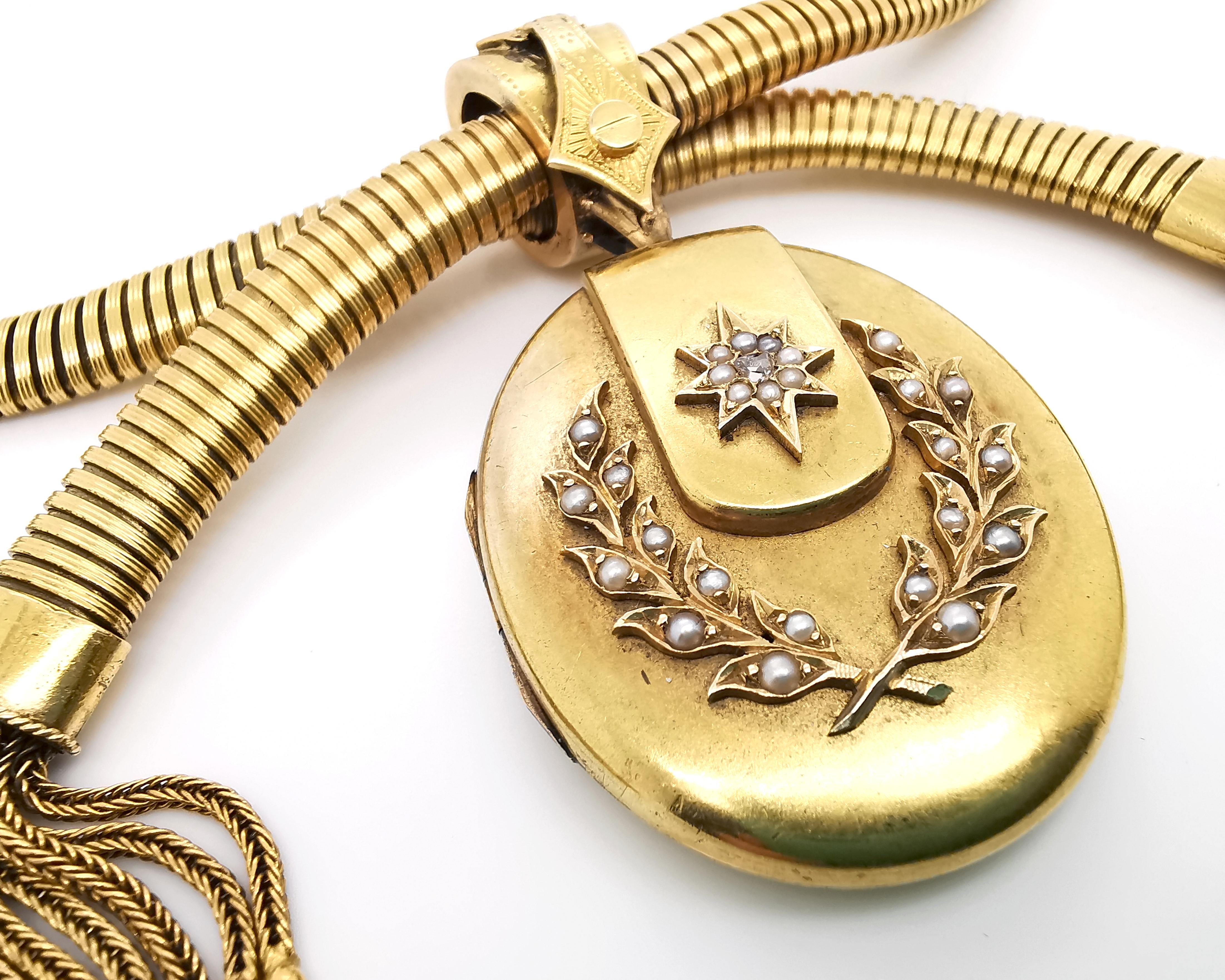 A Victorian gold gaspipe necklace with a locket and tassels, with a flexible gaspipe style collar, terminating in two tassels at the front with an oval hinged locket suspending from the centre decorated with an applied star and laurel wreath motif