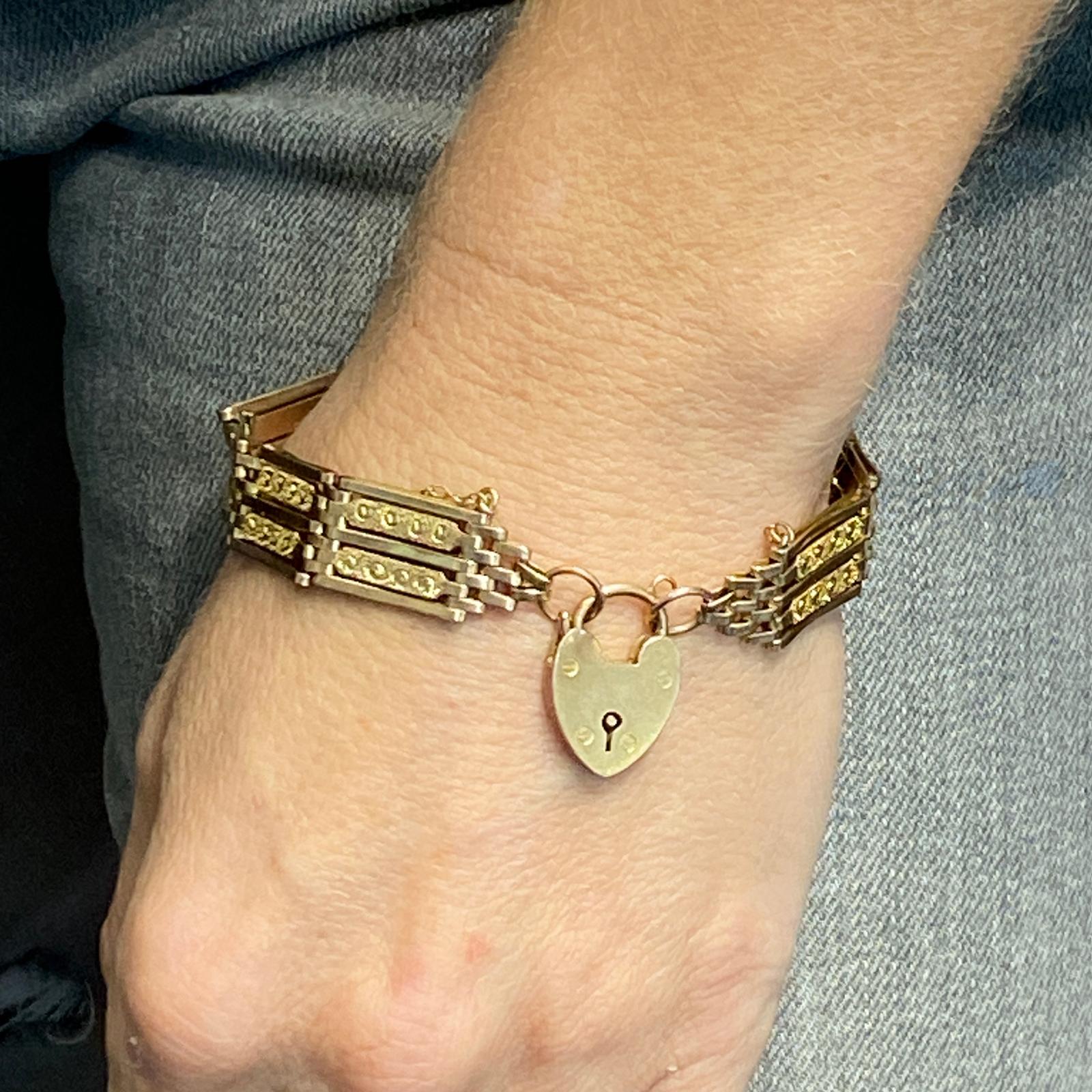 Original heart lock Victorian bracelet fashioned in 9 karat yellow gold. The gate links measure .50 inches in width, and the bracelet measures 7.0 inches in length. The heart clasp charm secures the bracelet and dangles. 