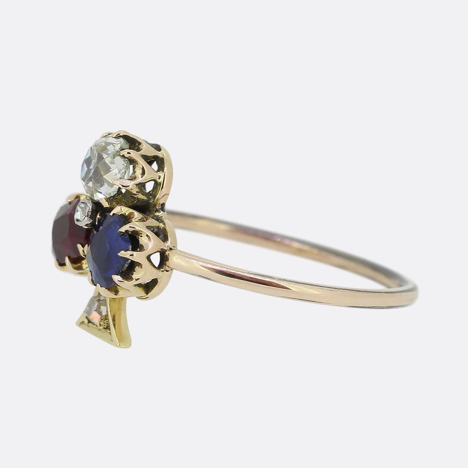 Hier haben wir einen charmanten viktorianischen Kleeblattring. Der Ring ist mit einem Trio runder Edelsteine besetzt, darunter ein Rubin, ein Saphir und ein Diamant im Altschliff, die zusammen das Kleeblattmotiv bilden.  Abgerundet wird dieses