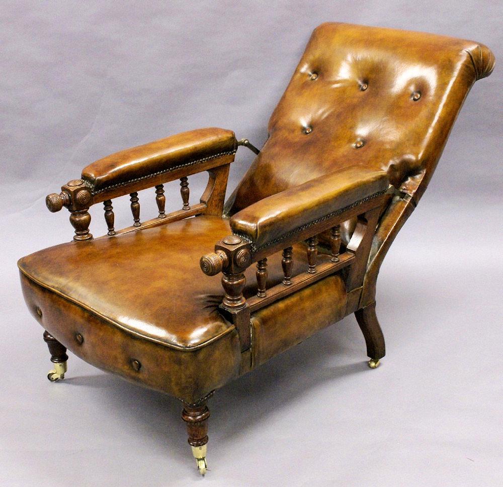 This extremely good looking and comfortable Victorian gentlemen’s leather armchair features an English oak frame with turned spindle arm supports and detailed carving on the end caps. The chair reclines by means of a mechanism concealed within the