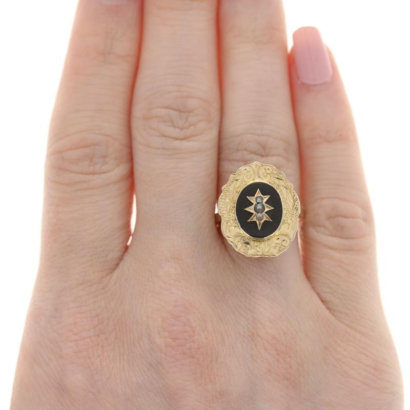 This rare gem dates c.1870s-90s and features three small genuine pearls set in an unique raised star symbol.  This star is displayed in the middle of an onyx stone with an oval shape that is bezel set.  Around this onyx stone is a beautifully hand