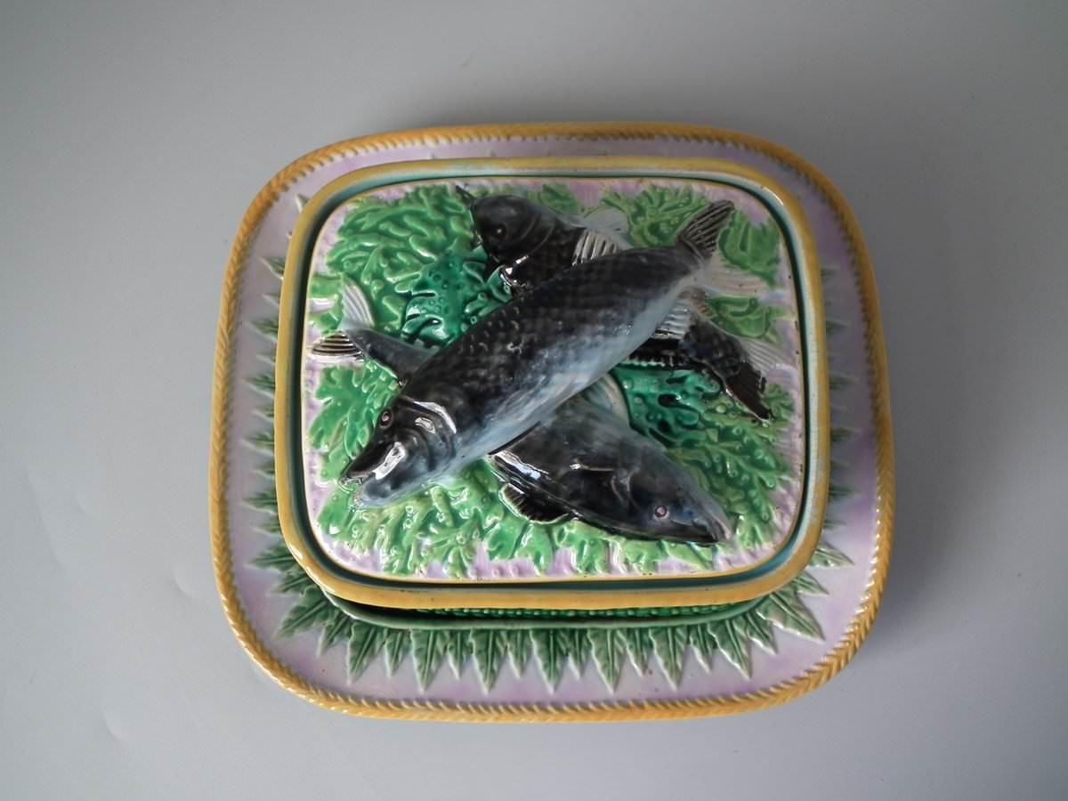 George Jones Majolica fish server which features a salmon laying on a bed of leaves. Coloration: brown, green, grey, are predominant. The piece bears maker's marks for the George Jones pottery. Bears a pattern number, '2763'.
 