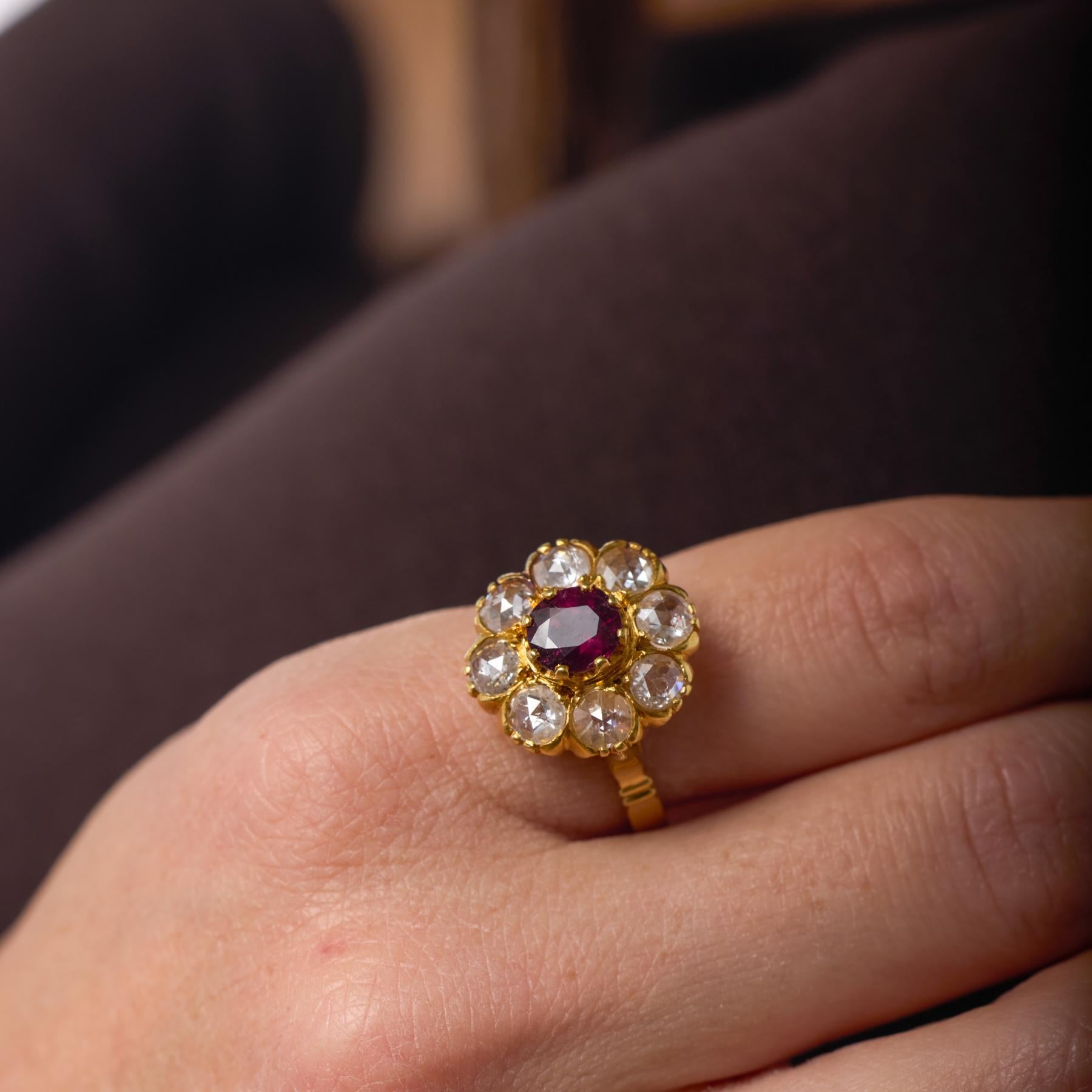 Cette bague victorienne en forme de grappe est centrée sur un rubis rouge pourpre richement coloré dont le ton profond et lumineux incarne l'élégance et le sentiment de l'époque. Entouré d'un halo de diamants roses étincelants, le rubis est rehaussé