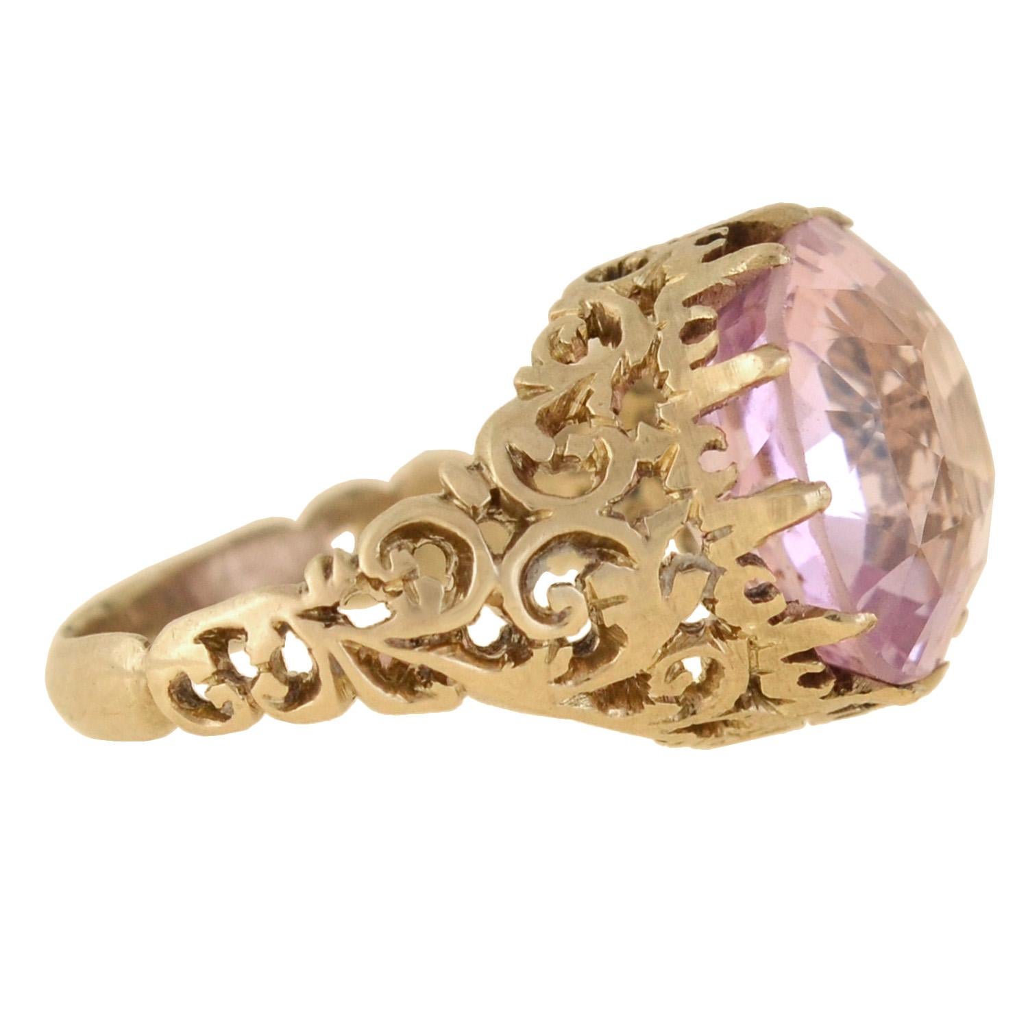 An exquisite pink sapphire ring from the early Victorian (ca1850) era! Crafted in 14kt yellow gold, this piece adorns a stunning 11.67ct Ceylon sapphire at the center of an intricate filigree setting. The Cushion Cut stone is of Sri Lankan origin,