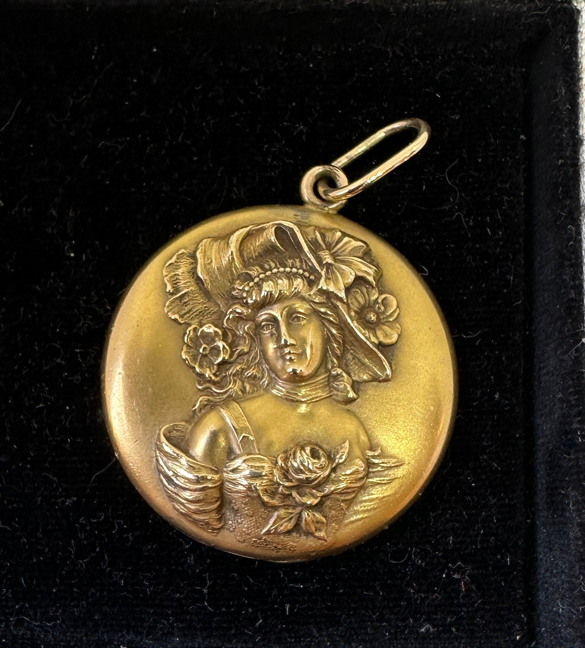 This is a gorgeous antique gold filled Victorian - Art Nouveau locket pendant which features a beautiful Gibson Girl woman maiden lady with flowing hair adorned with flowers wearing a bonnet and roses at her breast.  The deep repousse raised image