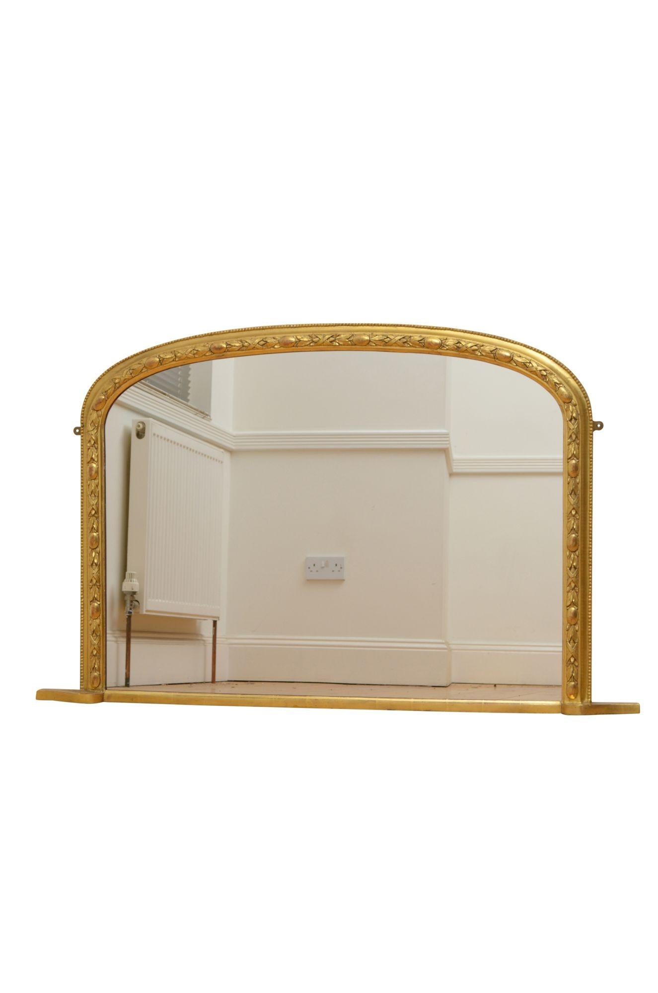 K0599 English Victorian giltwood over mantel mirror or arched form, having replacement mirror in moulded and beaded frame with carved leaf decoration in gold leaf finish. This antique mirror has been signed 8/6/83. Fitted with two hanging brackets