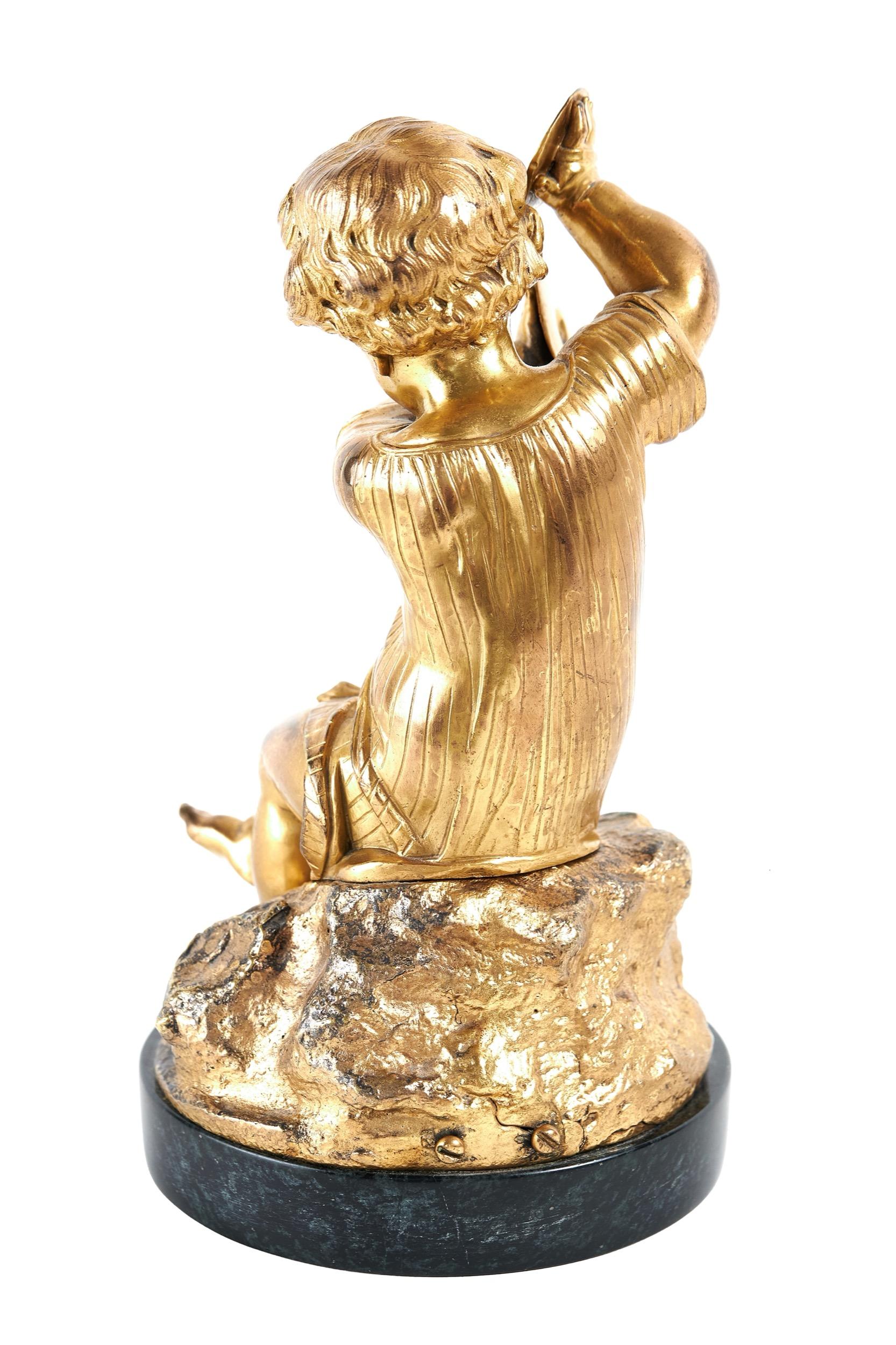 Figurine victorienne en bronze doré  un enfant jouant des cymbales
Assis jambes croisées sur un rocher, 
moulage fin et détaillé, sur le visage, 
Mains avec le ruban de cymbale enroulé autour, 
Rayures sur les vêtements
Détails musculaires sur les