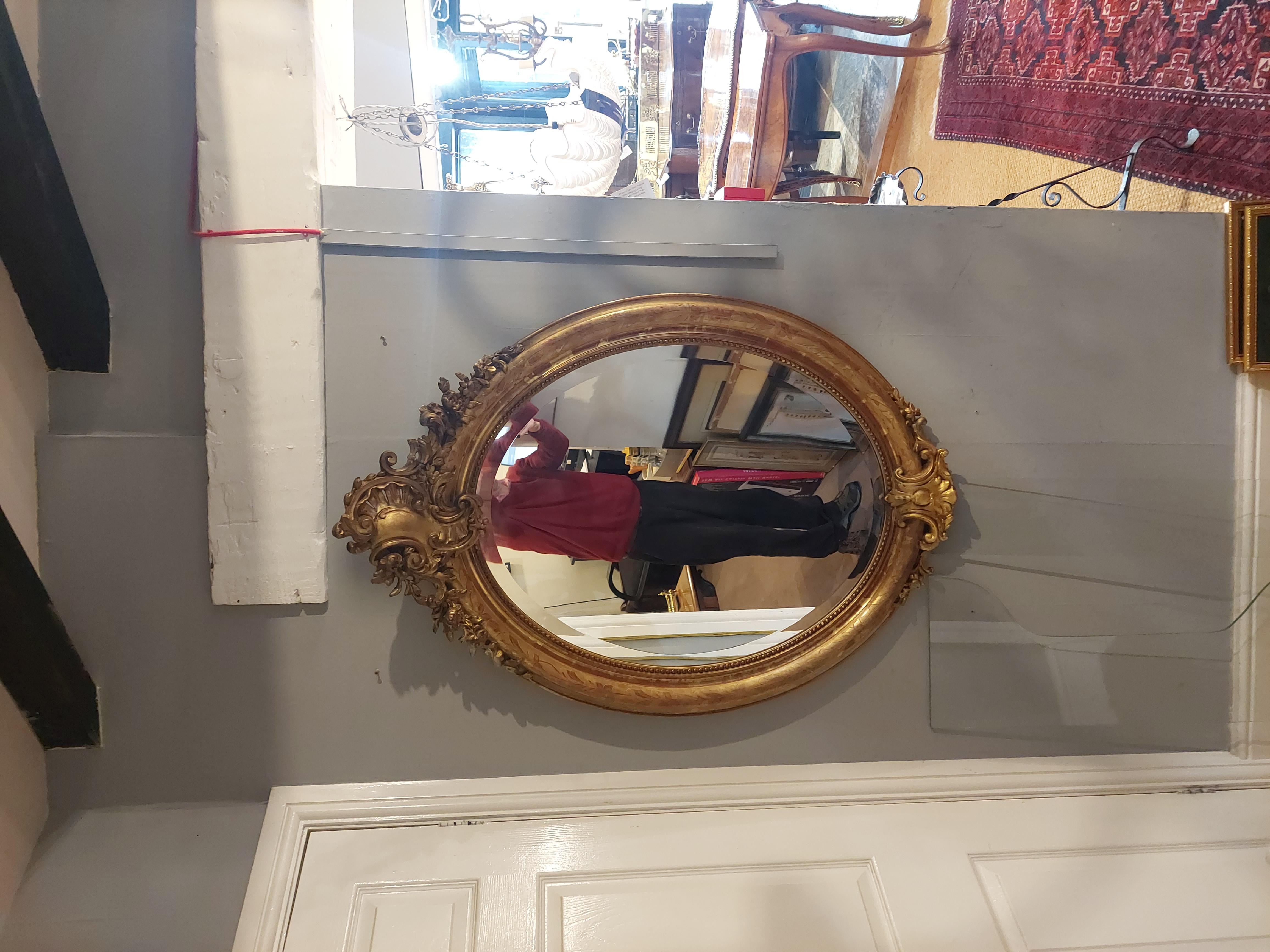 Victorian gilt-framed oval cameo Rococo wall mirror with C-scroll cartouche and bordered in scrolling foliate tooling and broadly bevelled glass 31