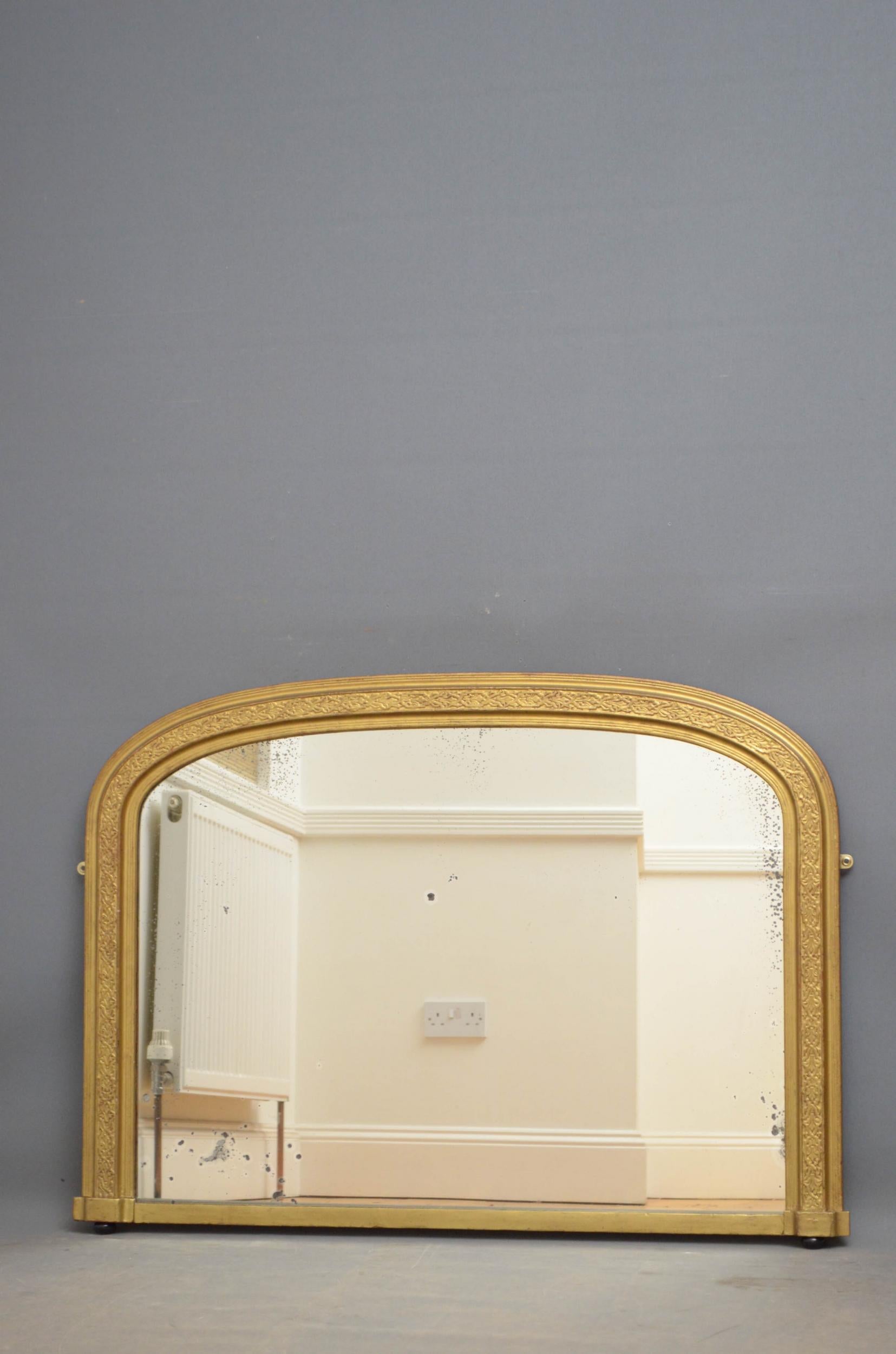 J00 Victorian giltwood arched wall mirror, having original foxed glass in carved frame with ebonized bun feet to the base. This antique mirror has been refinished in the past, it retains its original glass and backboards, all in wonderful home ready