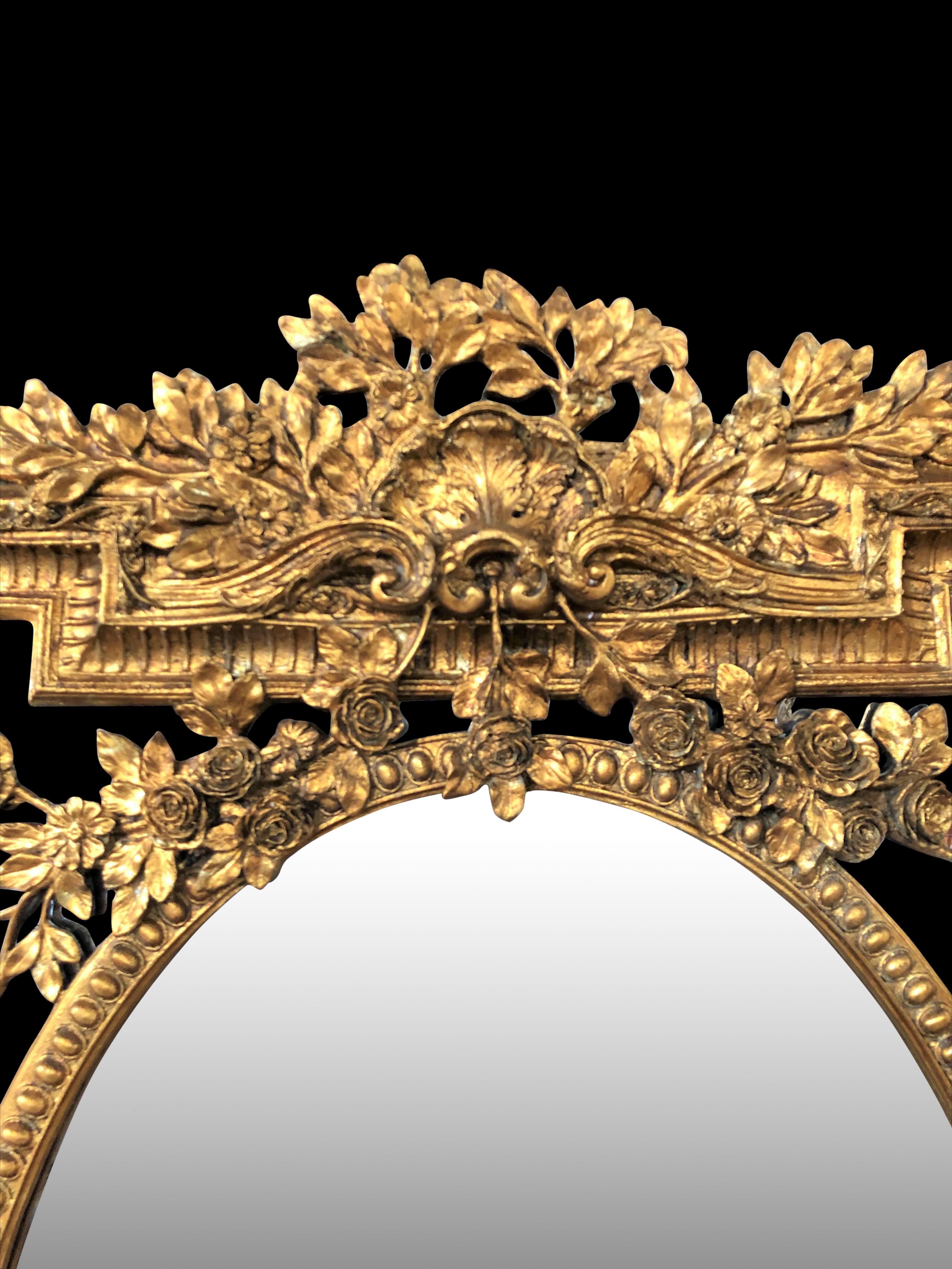 An elegant Victorian style gilt pier mirror, 20th century. Intricate gilt frame with floral motifs and vines. Glass is clear and blemish free ready to add light to any room. Comes in excellent condition.