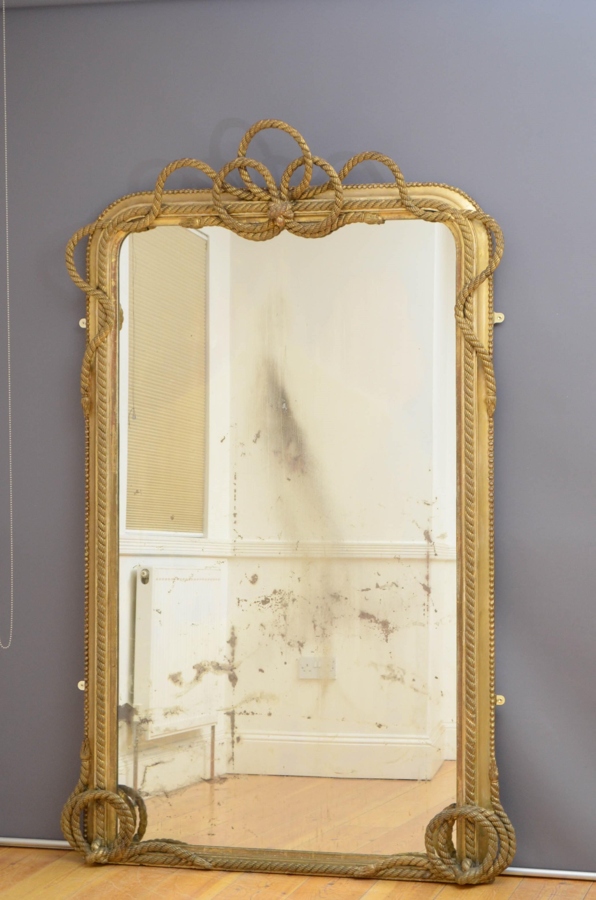 Sn5029, a large Victorian 19th century full length mirror, having original glass with age marks and foxing in moulded, beaded and gilded frame with rope scrolls to the base and rope centre crest decoration. This antique mirror retains its original