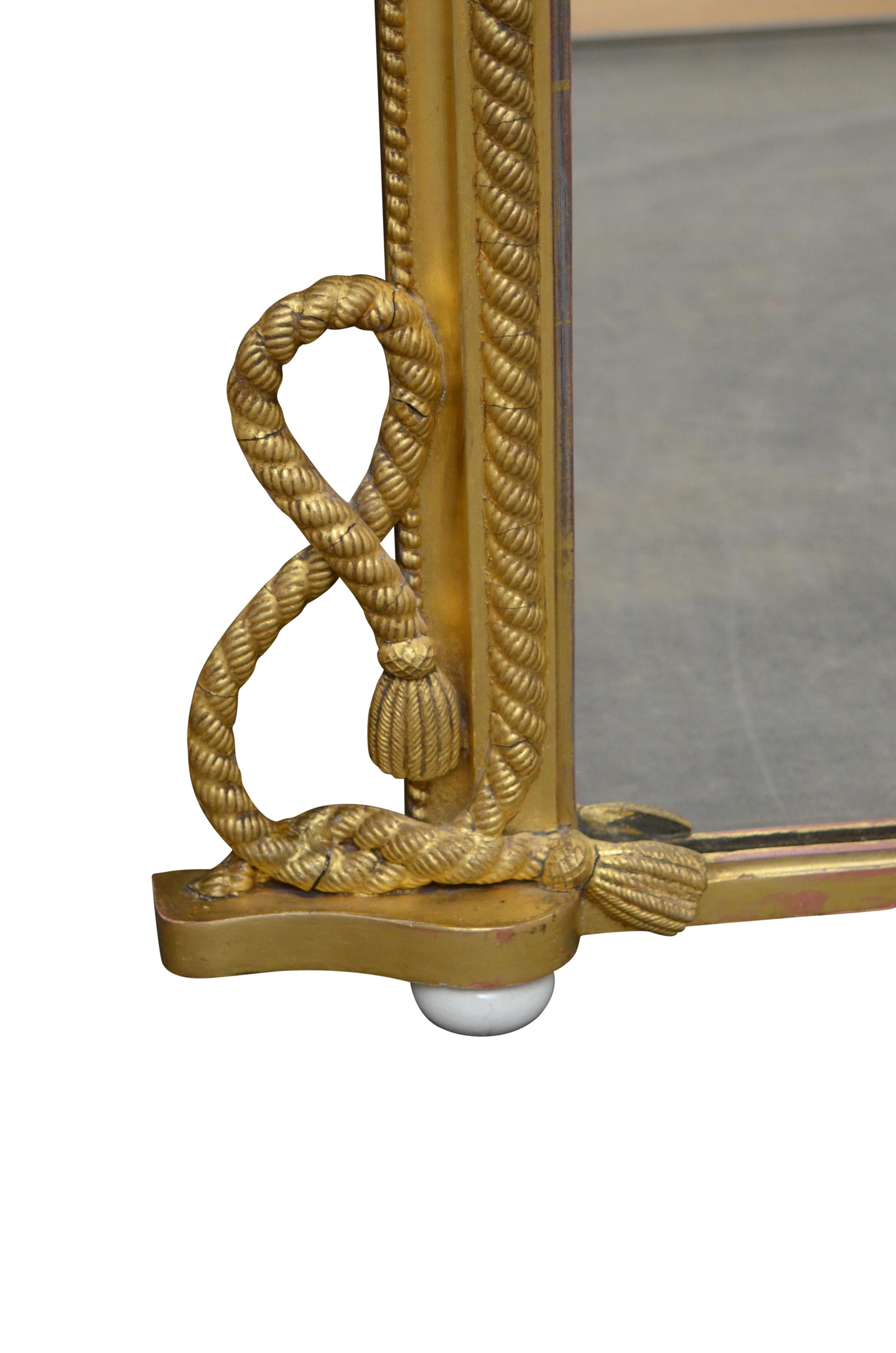 K0507 attractive Victorian gilt wall mirror, having original glass with some imperfections in finely carved frame with rope motif, rope crest with tassels and rope scrolls with carved tassels, all standing on removable porcelain feet. This antique
