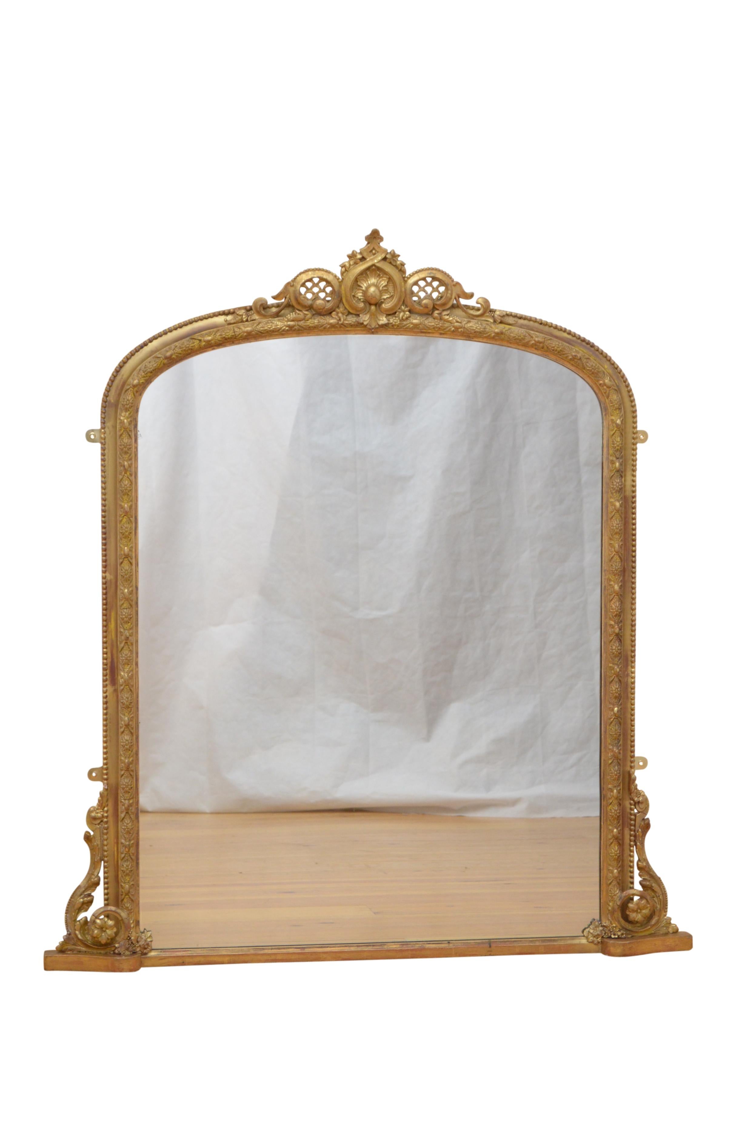 Elegant Victorian gilded wall mirror, having original glass with some imperfections in beaded and floral carved frame with foliage and lattice work crest to the centre and elaborate scrolls to base. This antique mirror retains its original glass,