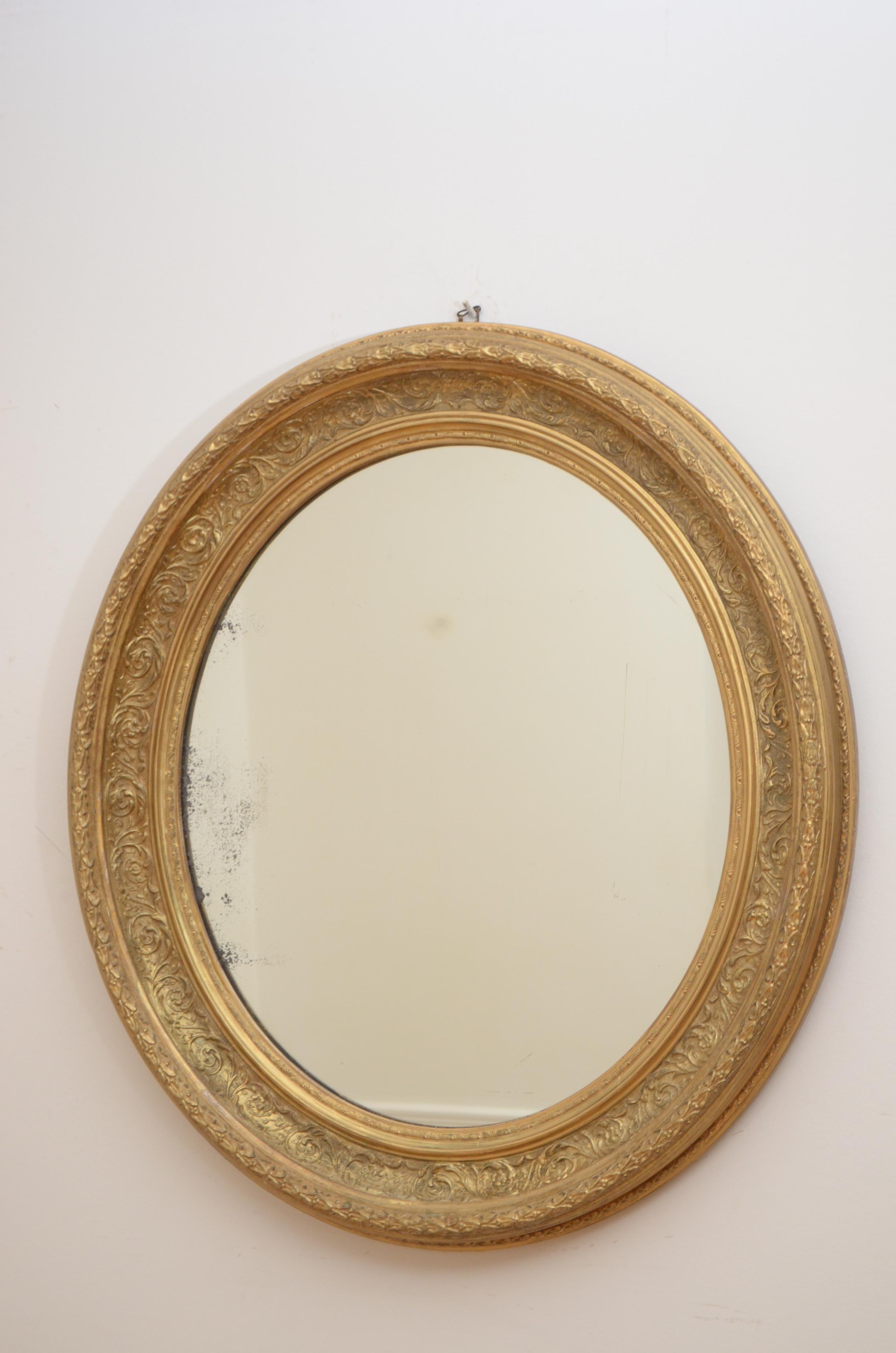 K0396, attractive Victorian oval mirror, having original glass with some foxing in floral decorated and gilded frame. This antique mirror retains its original glass, gilt with some touching up and backboard, all in excellent home ready condition,