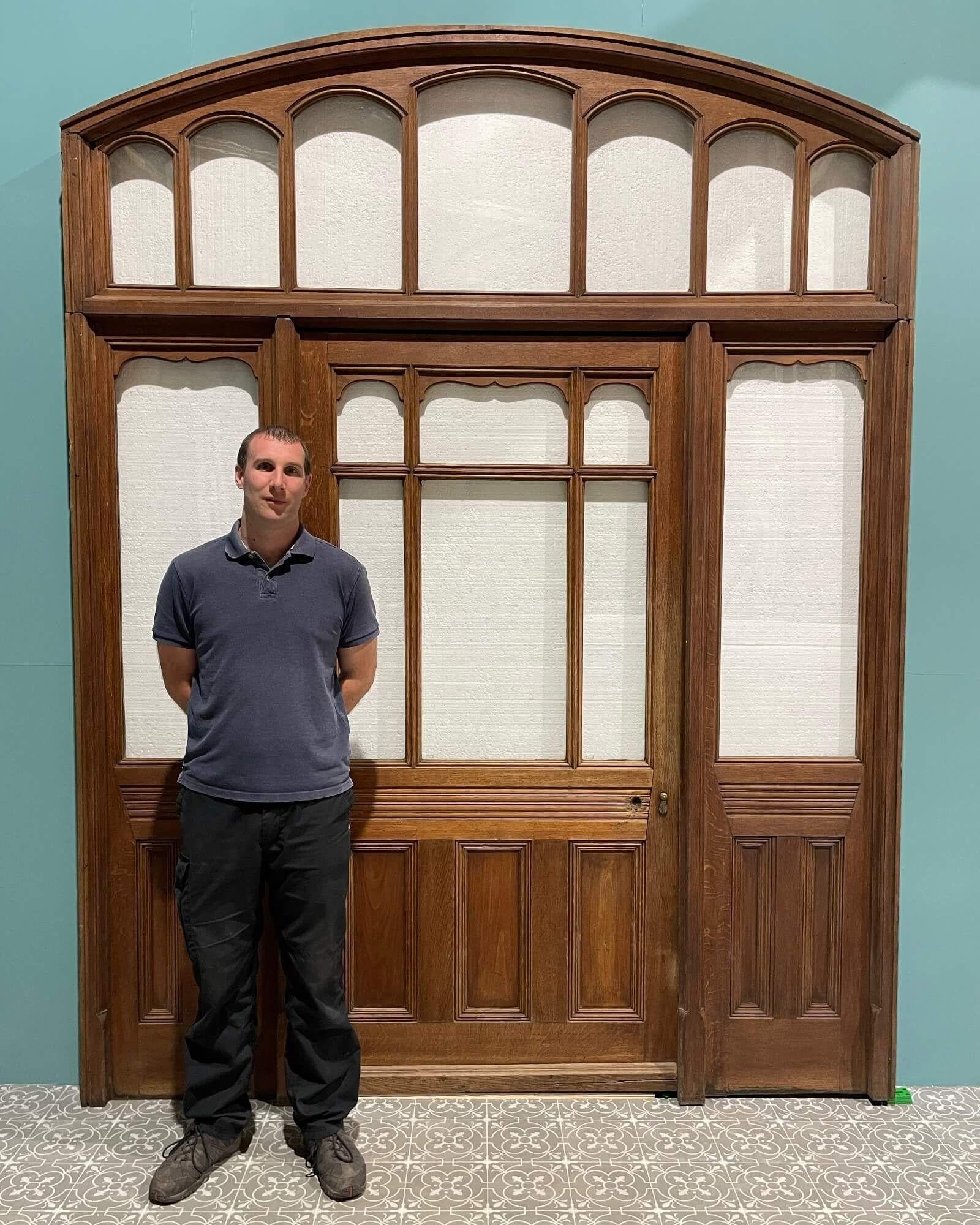 Ein viktorianisches, verglastes Eichenportal mit einer einseitig zu öffnenden Tür in der Mitte, feststehenden verglasten Seitenwänden und einem verglasten Rundbogenüberschlag. Mit einer Höhe von fast 3m / 9