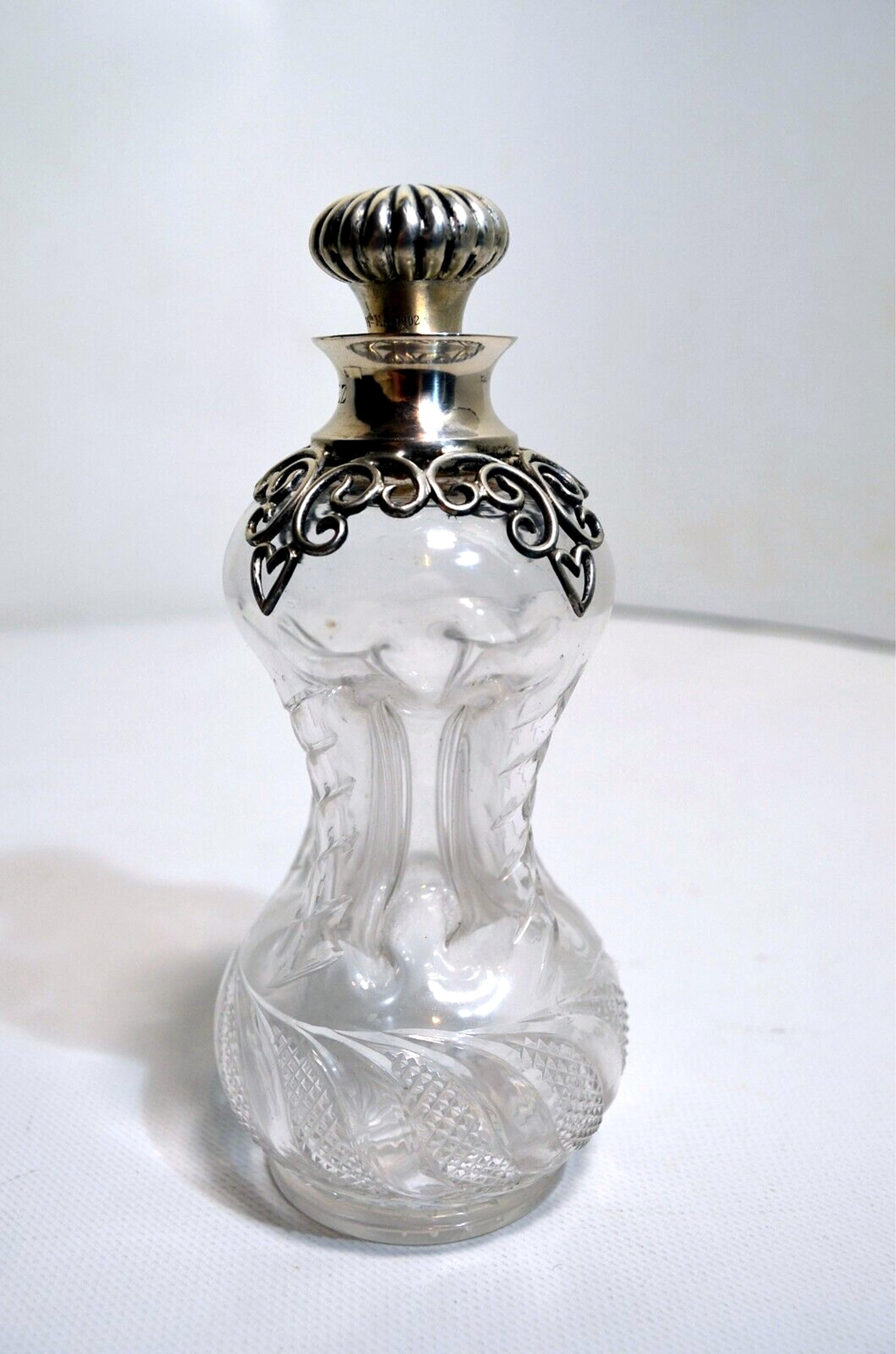 Very beautiful glug glug decanter bottle in cut crystal and solid English silver. The bottom of the bottle cut with a diamond-tipped twisted wheel. A star is engraved under the base. The setting is in silver marked London 1895. The goldsmith's mark