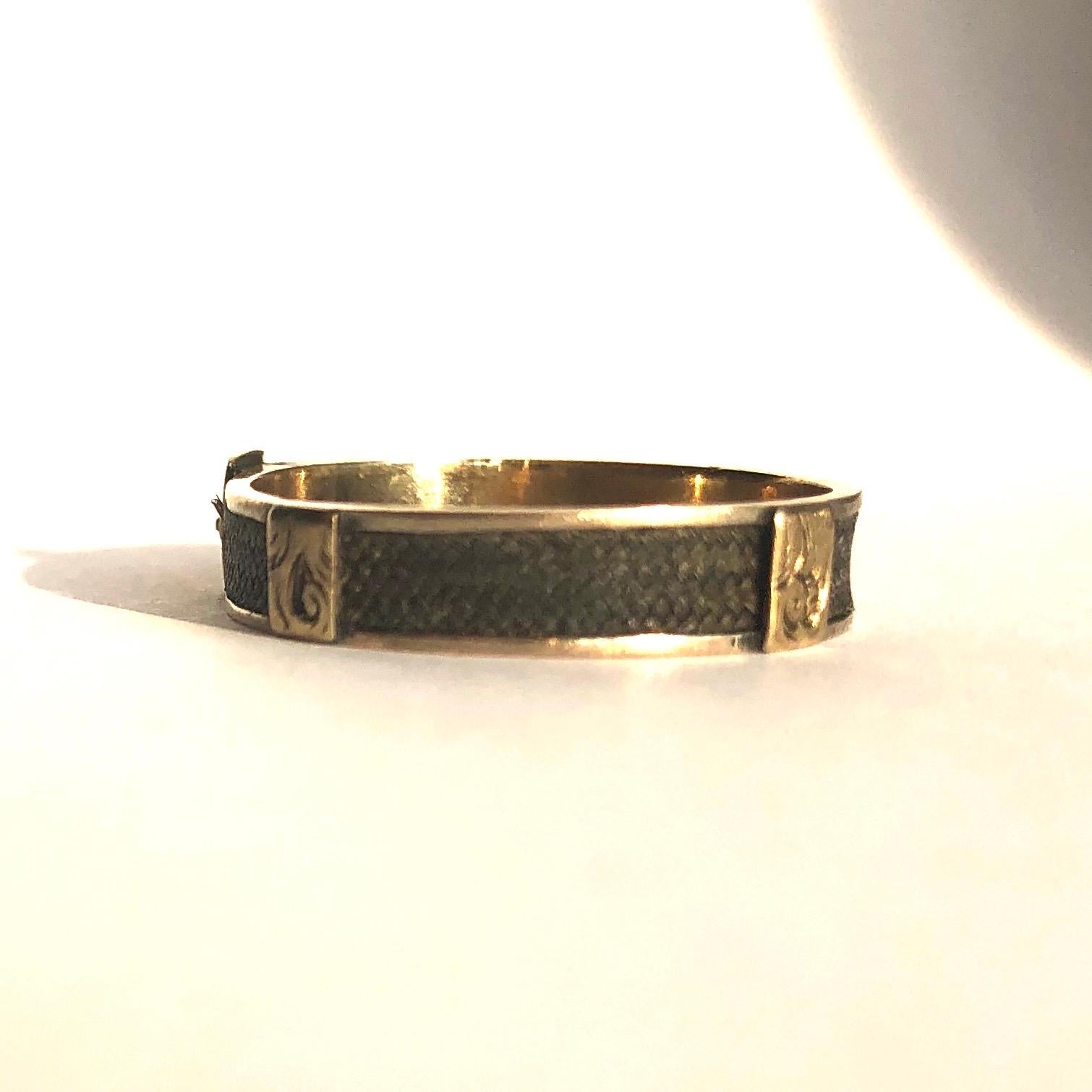 The buckle detail on this band is so fine and intricate with gorgeous engraving. The band holds a fine plait of hair which wraps all the way around the band. 

Ring Size: R or 8 1/2
Band Width: 4mm

Weight: 1.51g