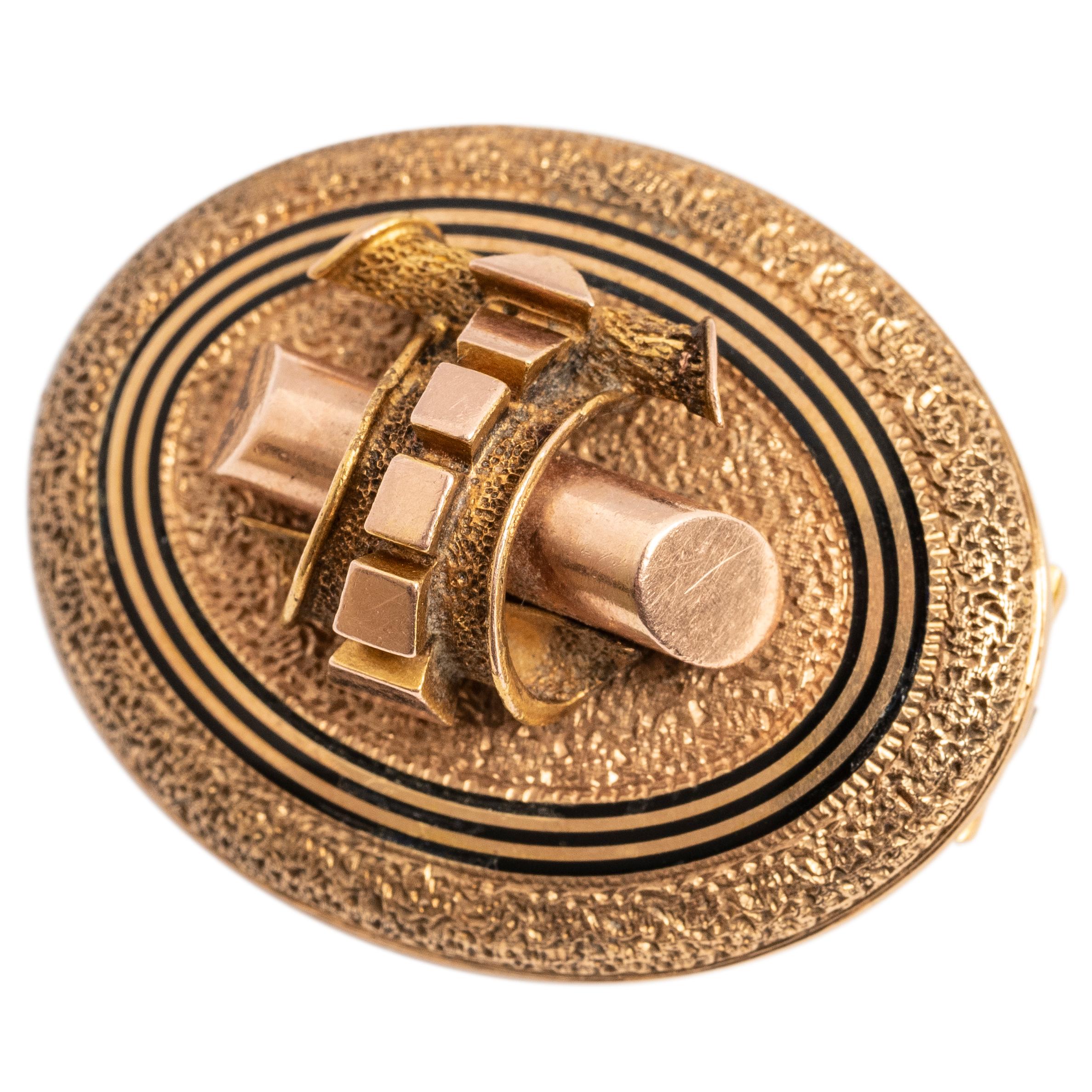 The rose gold brooch of textured surface enhanced with concentric black enamel bands, the reverse fitted with a gold hook and pin attachment. Perfect on a scarf or lapel, as a clasp shortener or suspending a pendant watch.

American or English 

1 ¼