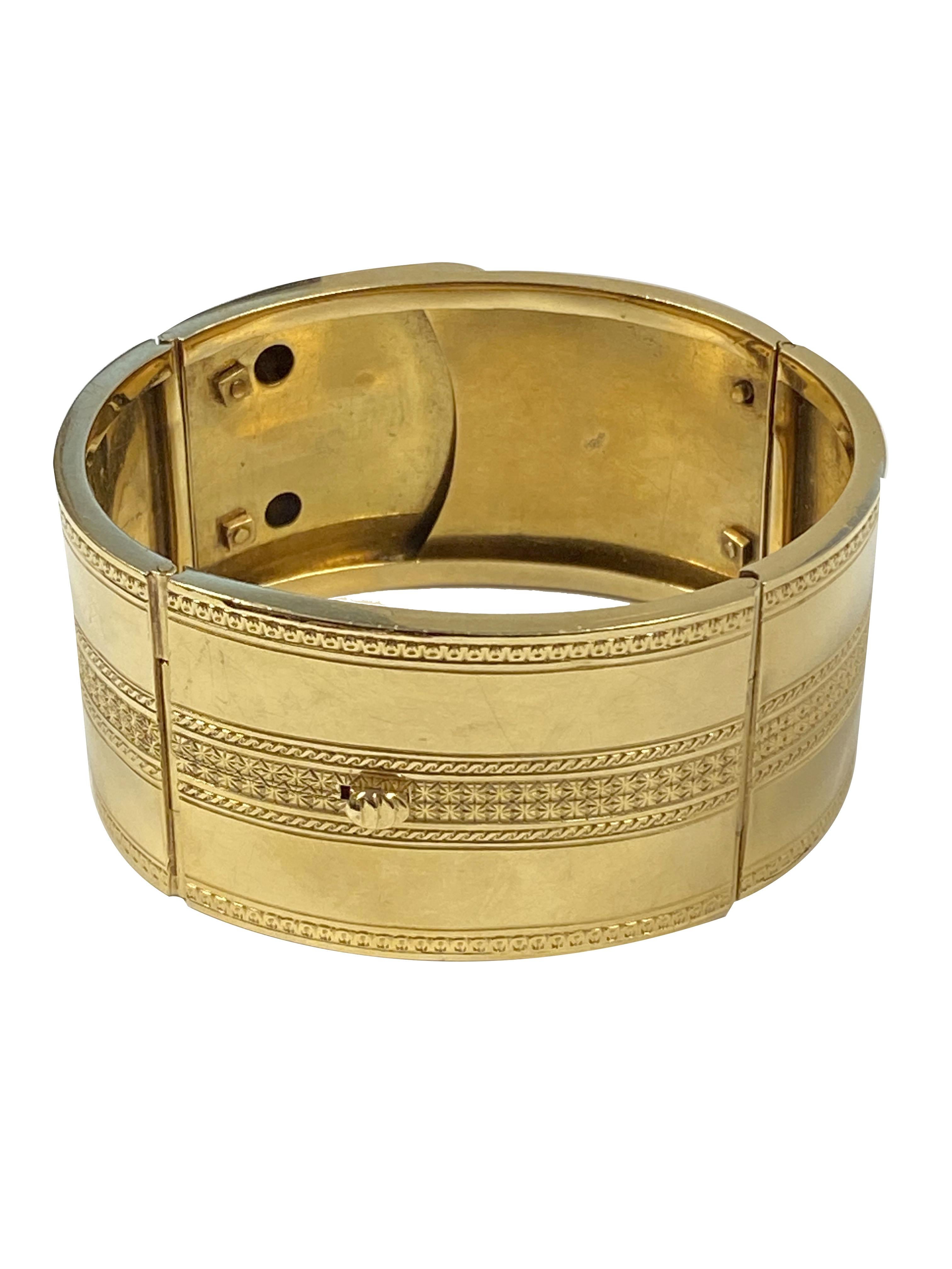 Circa 1880 14K Yellow Gold hinged Bangle Bracelet, measuring 1 1/4 inches wide, hinged in 4 sections for flexibility also features a locking clasp for easy on and off. The top sections are set with Emeralds, pearls and Rubies, further finished in