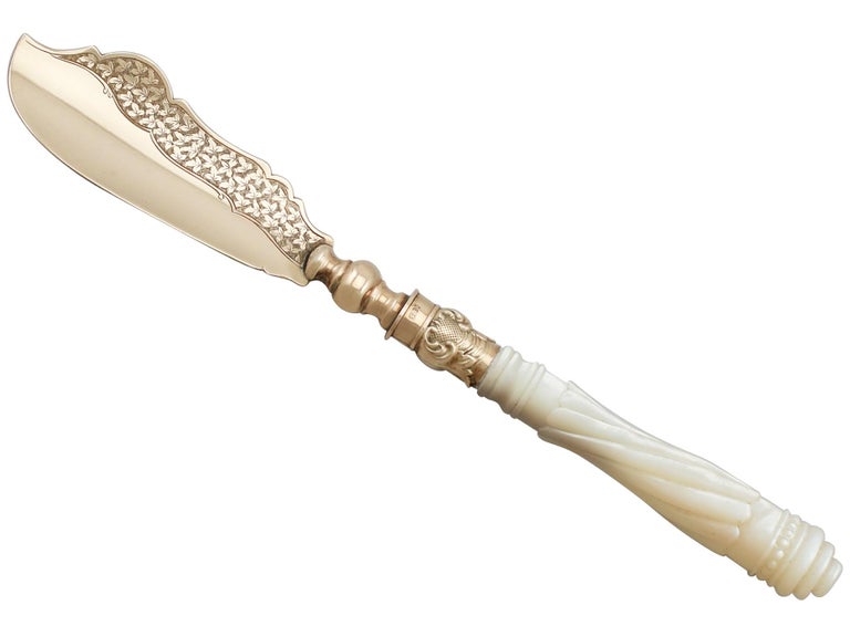 An exceptional, fine and impressive antique Victorian English 9-carat yellow gold and mother of pearl handled butter knife, boxed, an addition to our diverse flatware collection.

This exceptional antique Victorian 9-karat gold butter knife has a