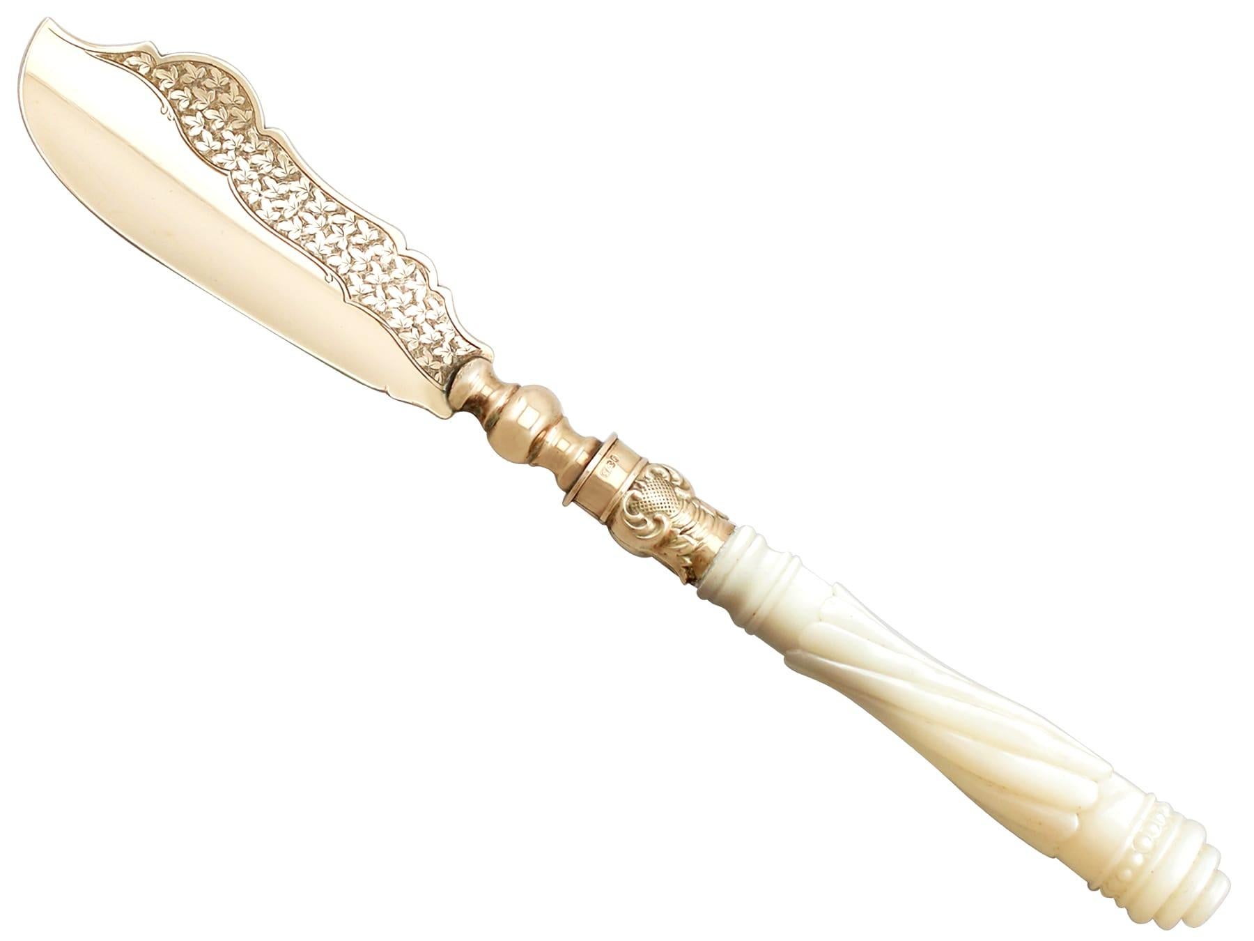 An exceptional, fine and impressive antique Victorian English 9-carat yellow gold and mother of pearl handled butter knife, boxed, an addition to our diverse flatware collection.

This exceptional antique Victorian 9-karat gold butter knife has a