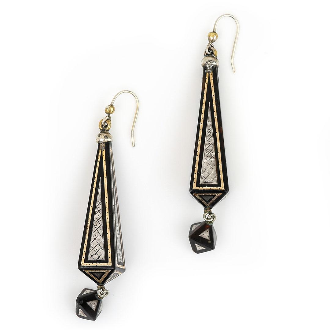 A stunning pair of Victorian yellow gold and silver inlay pique earrings hand crafted in circa 1880. The obelisk shaped drop earrings, beautifully inlaid with delicately designed panels of cross hatch geometric design. 

These antique earrings would