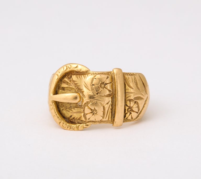 A  solid, warm tone 15 Kt gold buckle ring,  like the buckle motif bracelets of the Victorian era symbolized two people united, joined together as one. The ring is engraved with roses, the flower of love, friendship and passion as well as the leaves