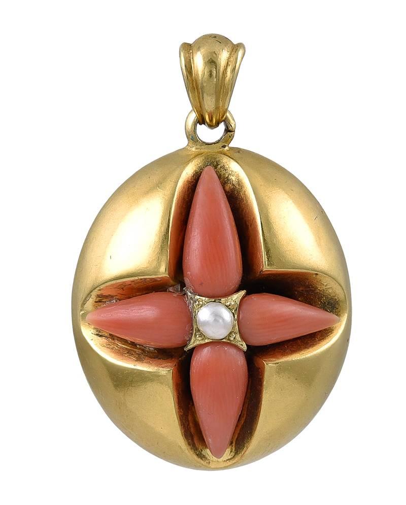 The 4 drop shaped Corals forming a Cross with a Pearl at the centre,  the reverse has a glazed compartment for a momento or portrait. Made of unmarked 15k Gold and in immaculate unworn condition.
Dimensions: 1.5 ins long (including the bale) x 1 ins