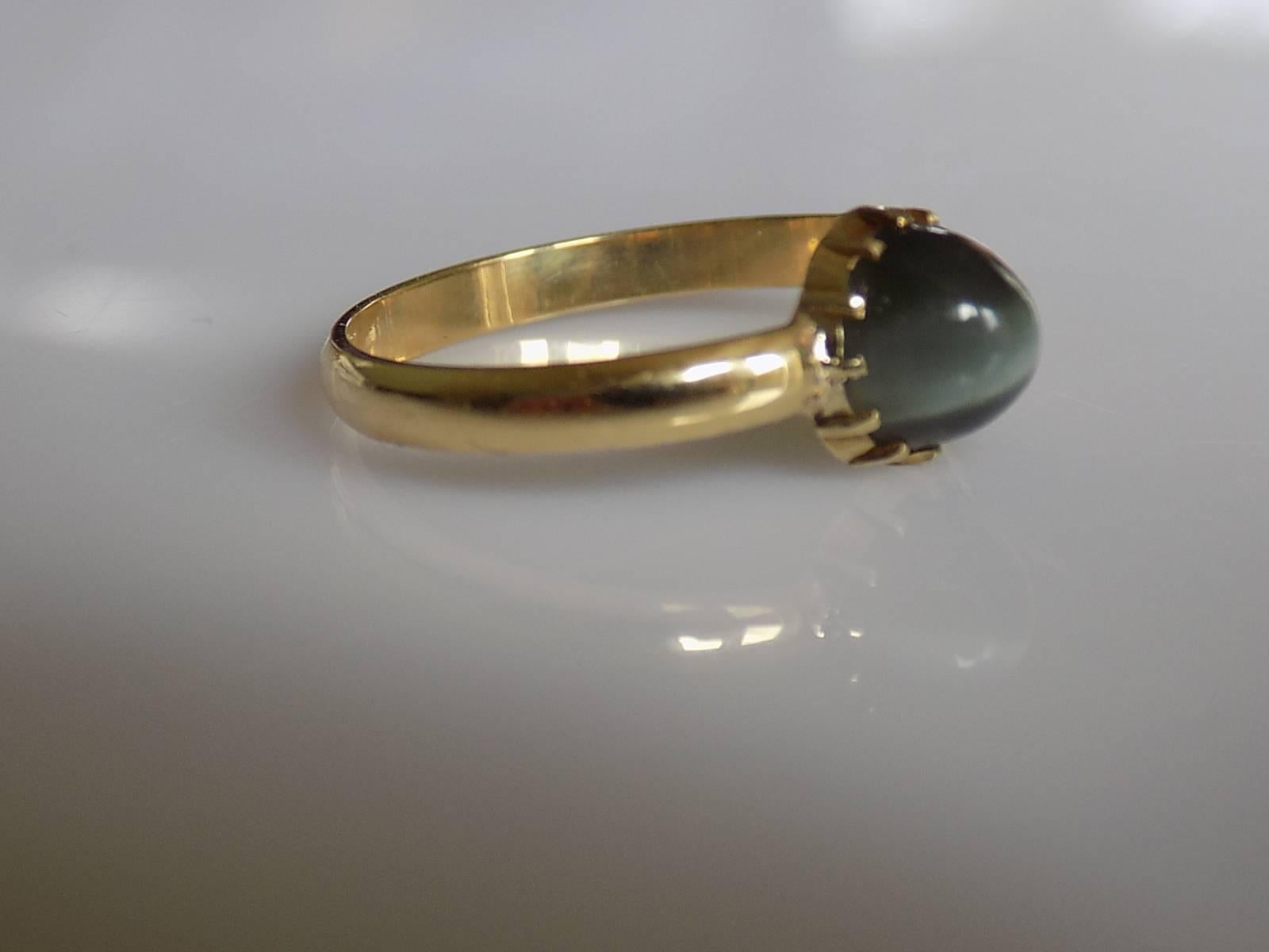 A Lovely Victorian c.1880s Cat`s Eye Chrysoberyl cabochon solitaire ring on later 18 carat Gold shank. English origin.
Size R UK, 9 US (sizeable).
Height of the face 8mm.
Weight 2.7gr.
Full London hallmark for 18 carat gold.
The ring in very good