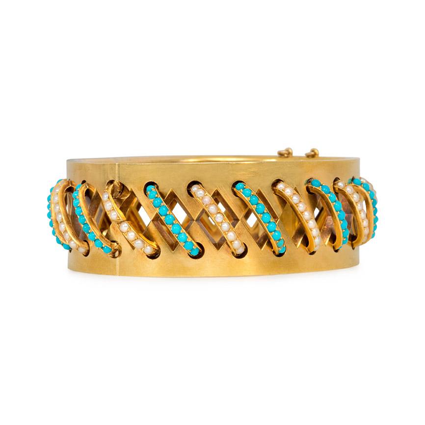 An antique gold, turquoise, and pearl cuff bracelet with repeating lozenge-shaped cutouts, bridged by diagonal bands of alternating pavé turquoise and pearls, in 18k.  In superb condition.  Dimensions: 6