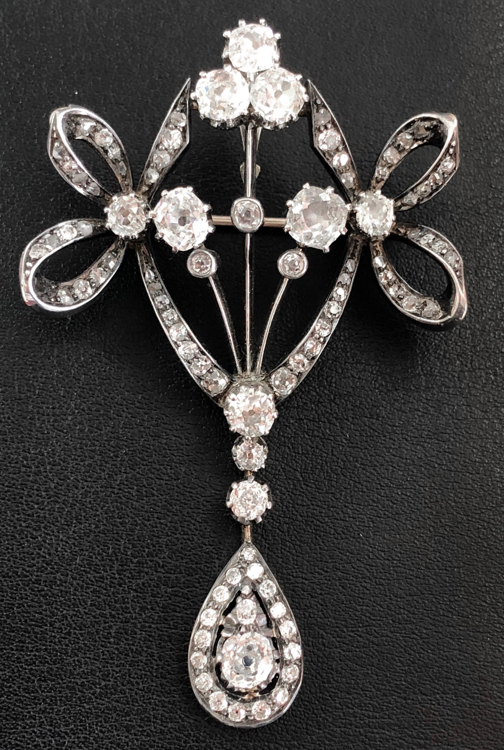 A bow shaped diamond brooch/pendant from the Victorian era, ca. 1880s. It is studded with old European and cushion cut diamonds, weighing circa 5 carats.