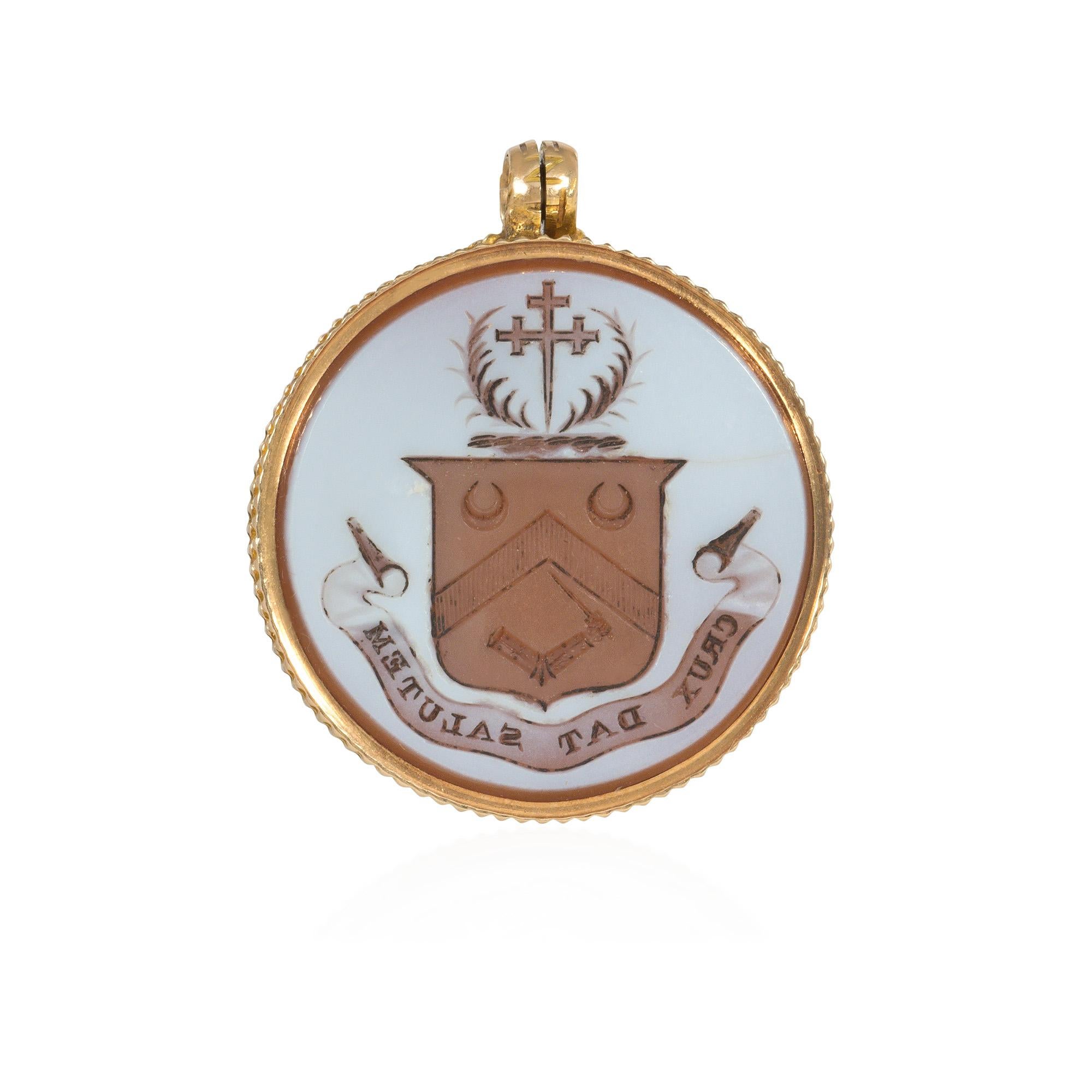 A Victorian gold and hardstone double-sided locket pendant featuring a bloodstone on one side and a carnelian on the verso with a carved crest and inscribed, 