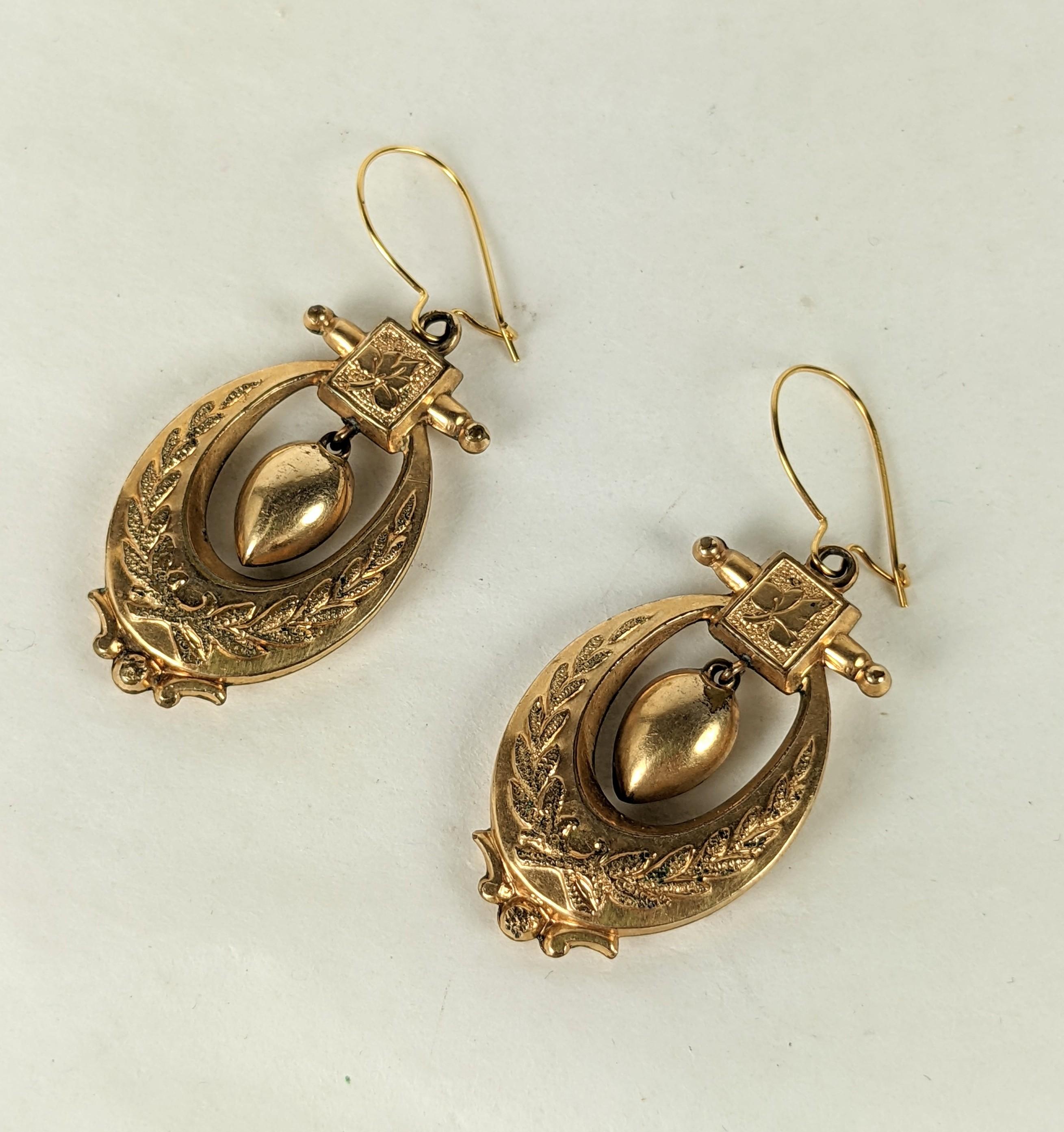 Charming Victorian Gold Filled Dangle Earrings from the late 19th Century. A pair of chased ovals with wreath motifs each have an urn shaped drop hanging from a leaf decorated motif. 
1880's USA. New wires. Motif 1
