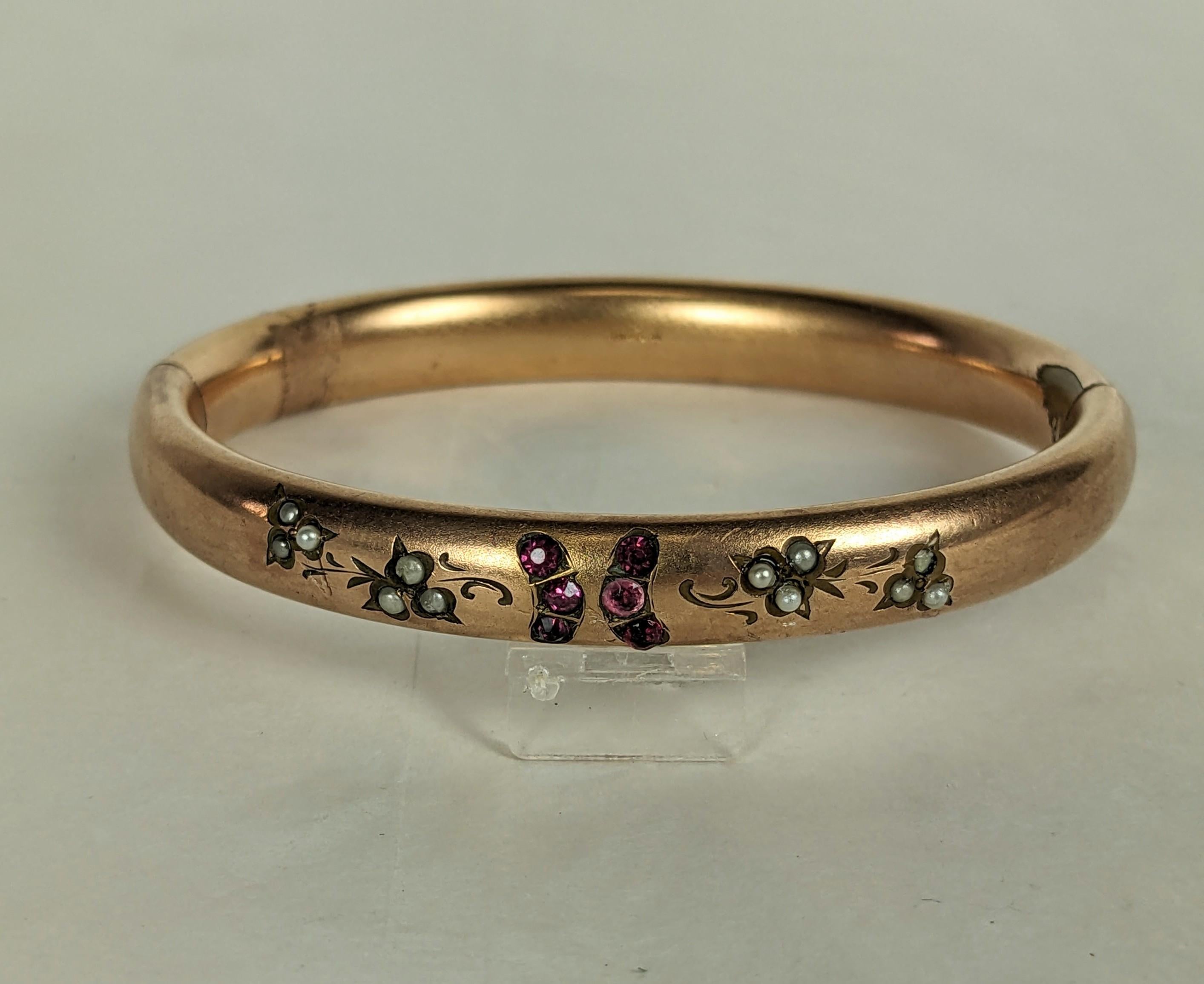 Bracelet victorien en pâte d'or du 19e siècle. Serti de pâtes de rubis et de fausses demi-perles sur le dessus avec ouverture à charnière. 3/8