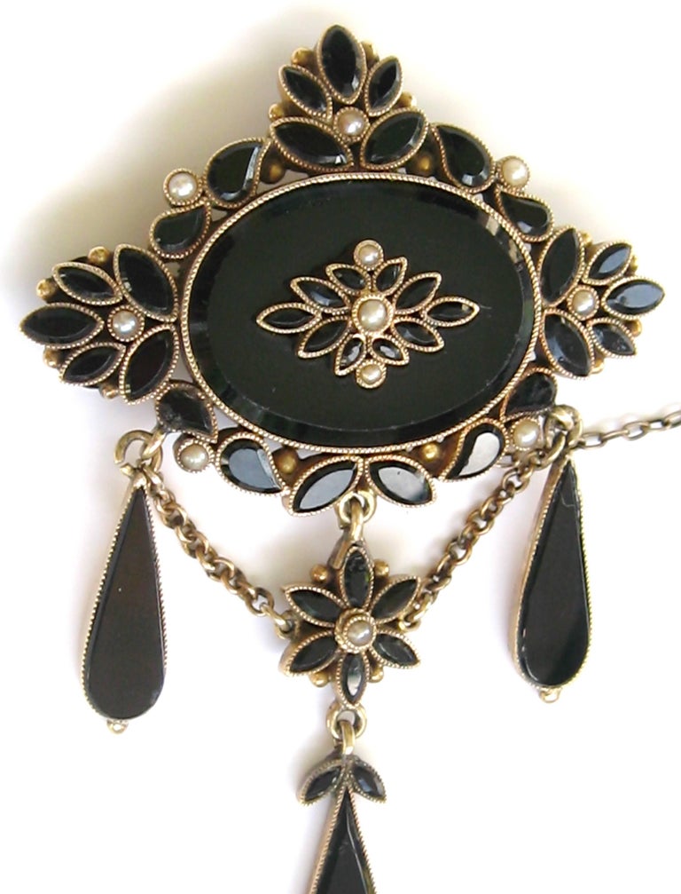 An exquisite piece of Victorian Mourning Jewelry. The pin is made up of either French Jet or Black Onyx and Seed Pearls set in 14 Kt Gold. The floral center drop is stunning. The pictures show you just how wonderful this is. The detailing on this is