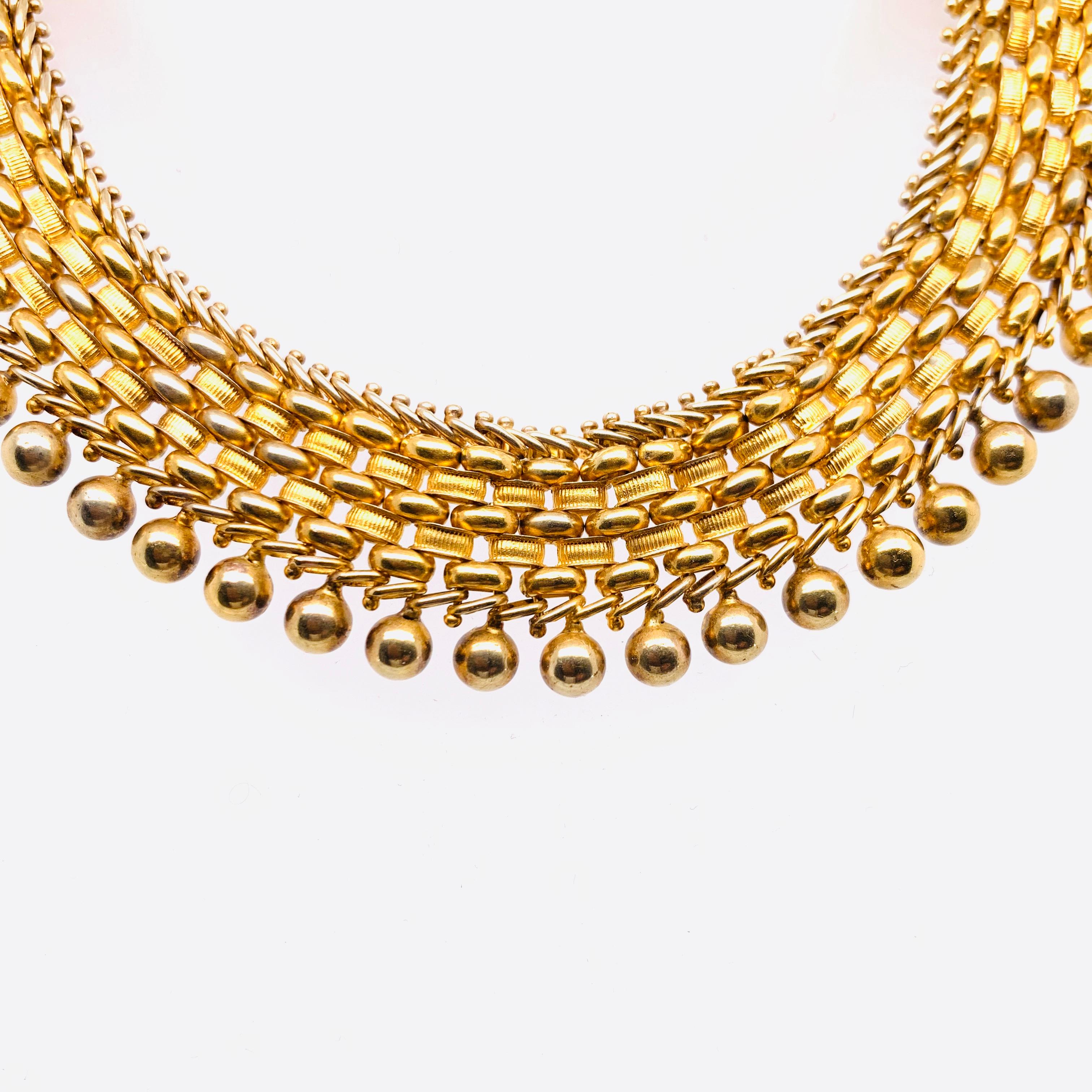 A Victorian gold collar necklace, with a woven design, featuring three rows of D cross-section, polished, links, alternating with two rows of reeded links, flanked by diagonal wire links, with gold bead detail around the outer edge. With a concealed