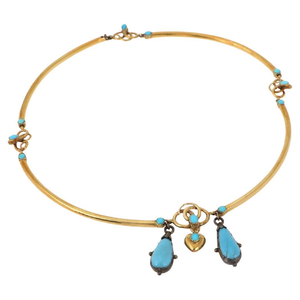 Victorian style gold necklace from the mid-19th century with turquoises and a snake motif.

Made of four links made of 18-karat blown gold, which are connected by elements in the shape of intertwined snakes, whose heads are set with turquoises.

The