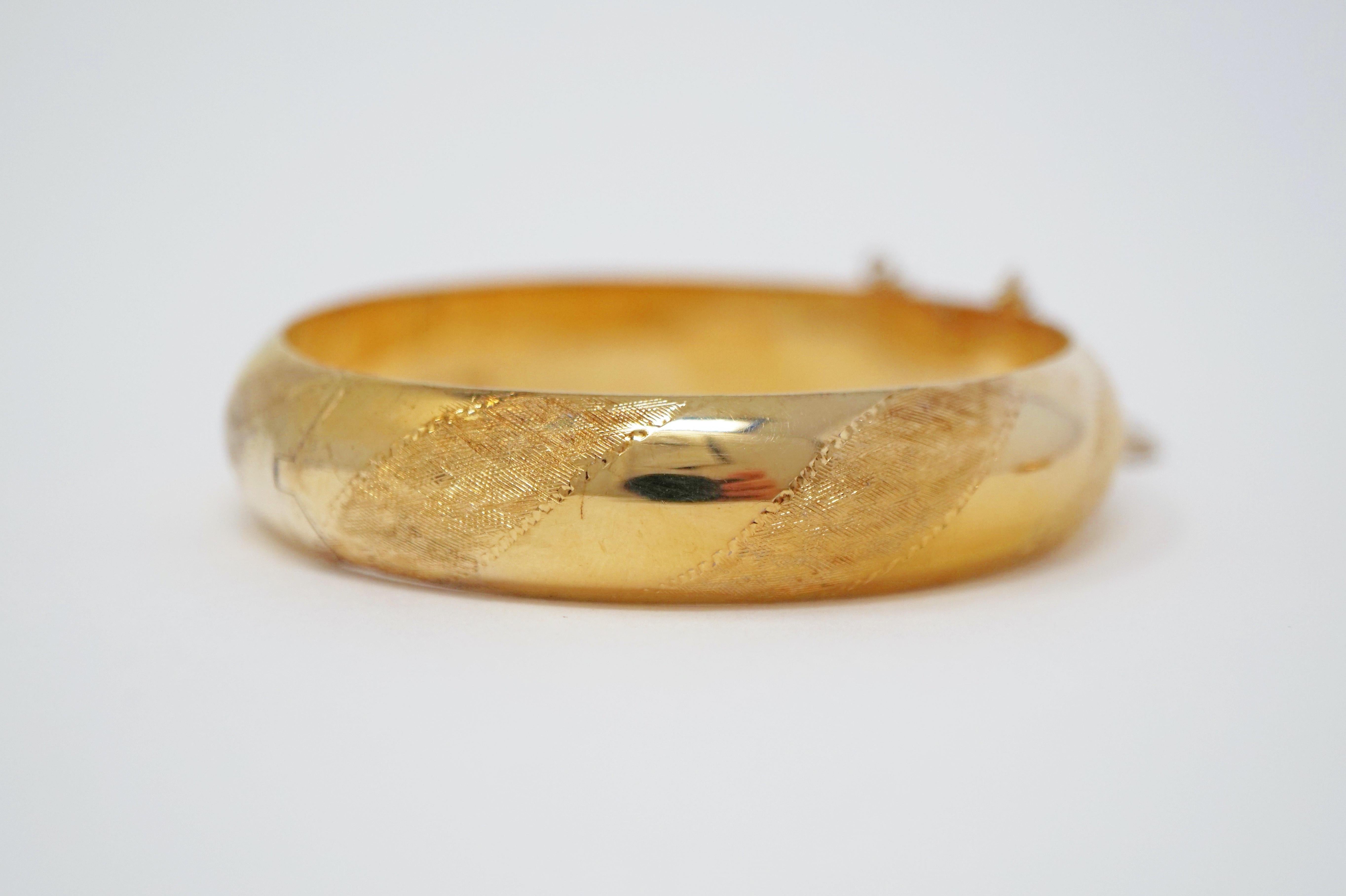 This Victorian gold vermeil (gold over sterling silver) hinged bangle bracelet is a beautiful treasure from a bygone era.  Textured striped details decorate the entire surface, while the interior is stamped 