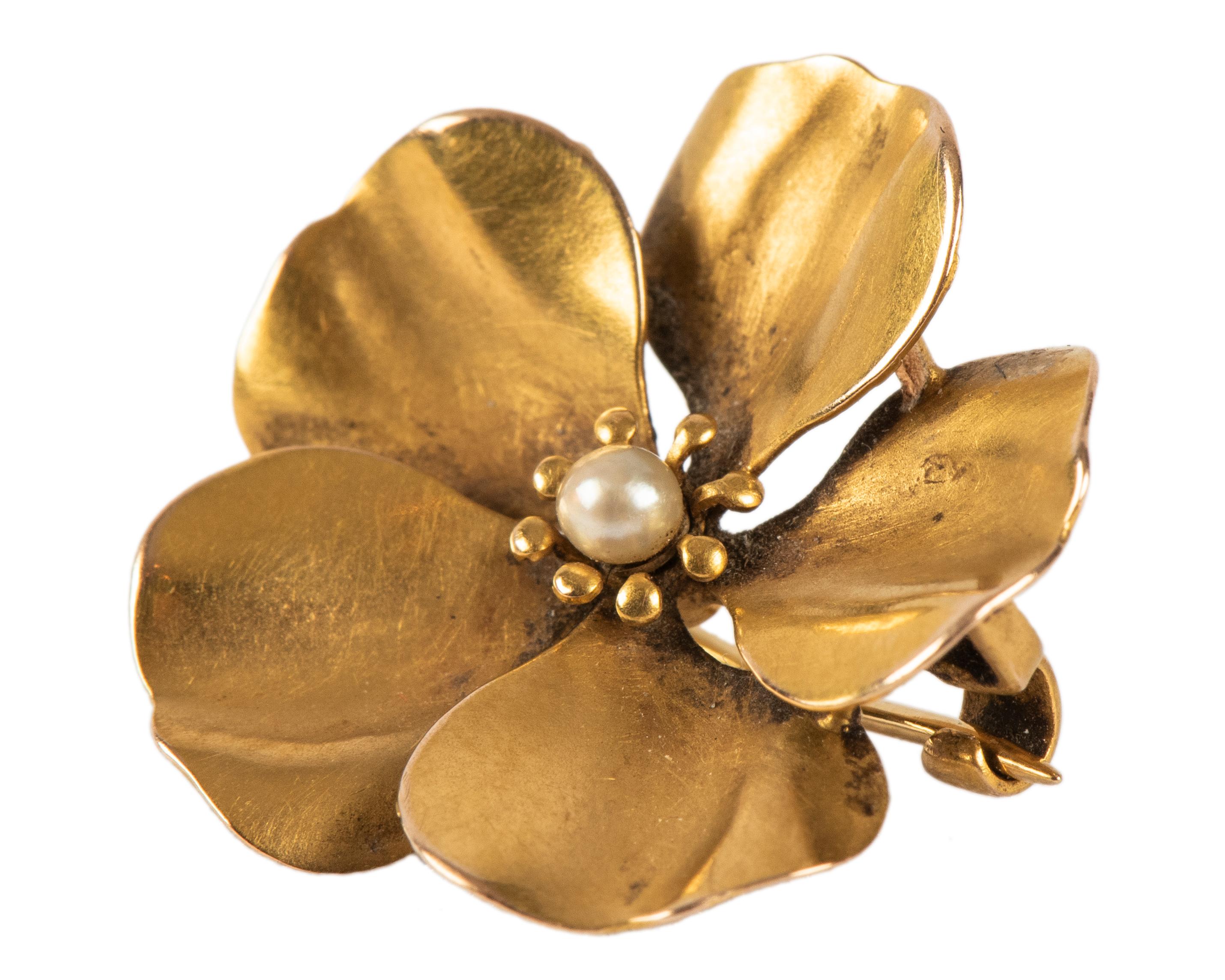 A small gold pansy pin with overlapping petals of matte gold centering a seed pearl.

American, circa 1890

5/8 in. (1.6 cm) diam.
