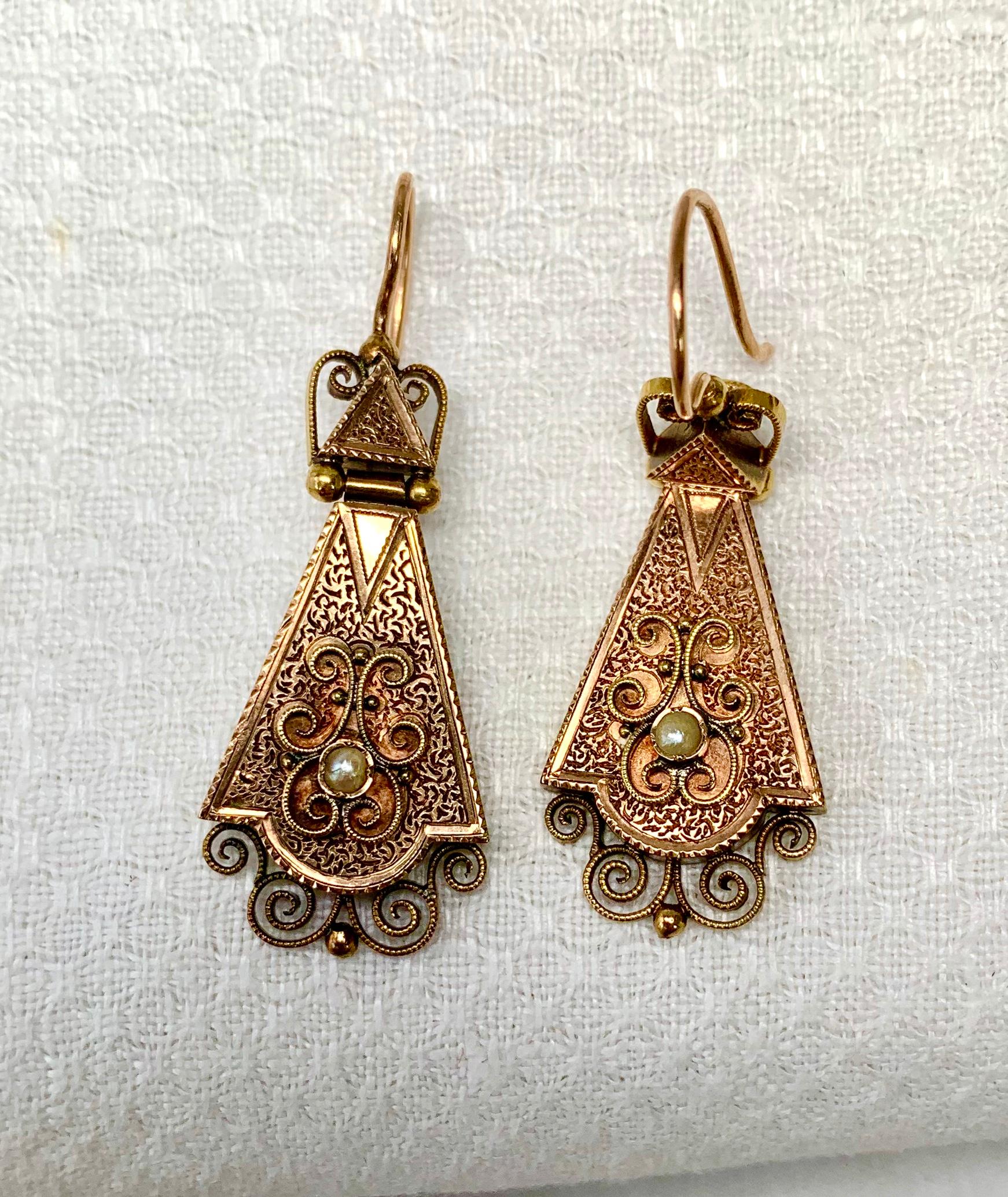 A spectacular pair of early Antique Victorian 14 Karat Gold Articulated Pendant Earrings with stunning engraving throughout.  Further enhanced with applied filigree work with pearl accents.  The earrings are articulated - the top triangle is hinged