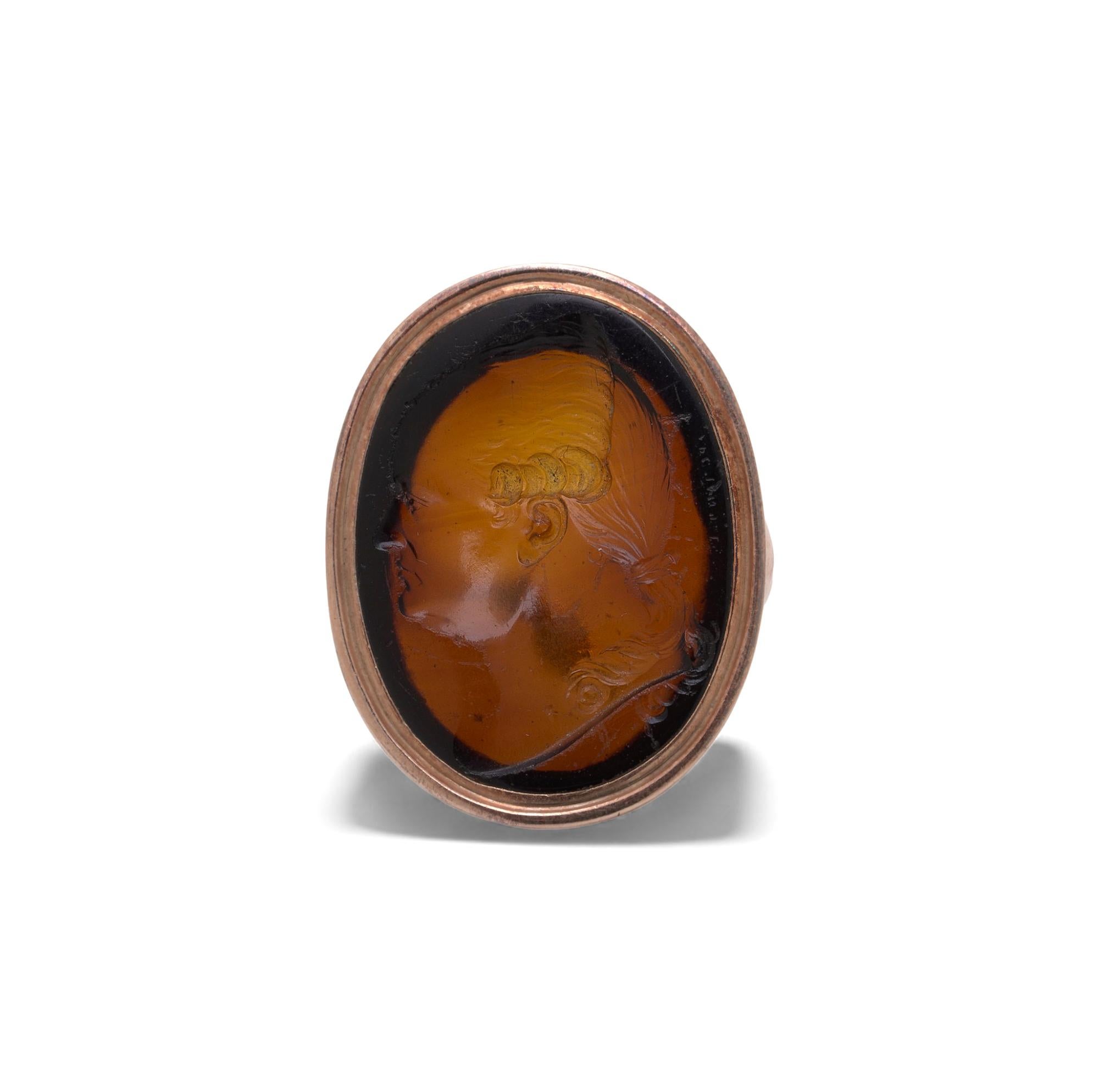 A Victorian 12ct gold ring set with an 18th-century intaglio carved in rich amber-toned agate. The oval intaglio depicts a classical male profile typical of Georgianera seal engraving from the 1700s, displaying crisp surviving detail around the
