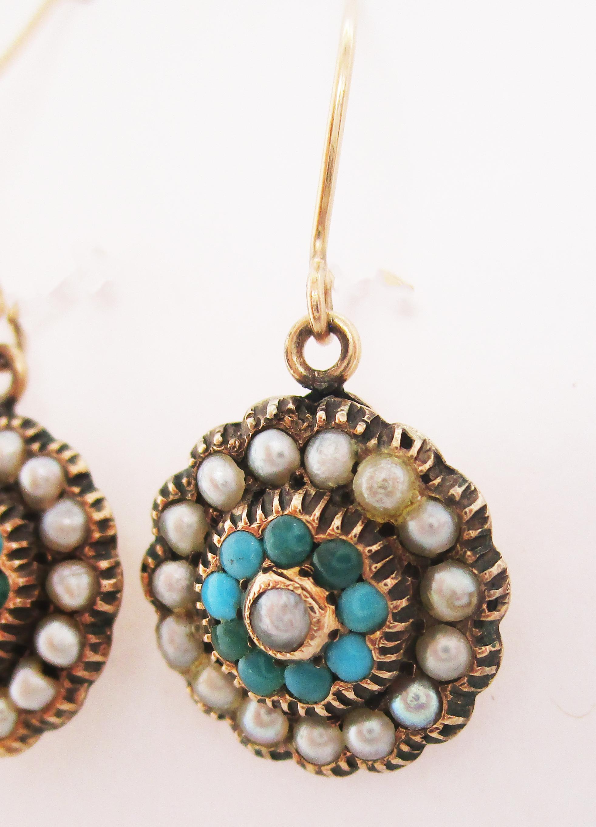 These beautiful Victorian earrings feature bright gold, richly colored turquoise, and soft white seed pearls all in an elegant dangle design. The earrings have a gorgeous concentric circle design featuring a pearl center framed by a row of turquoise