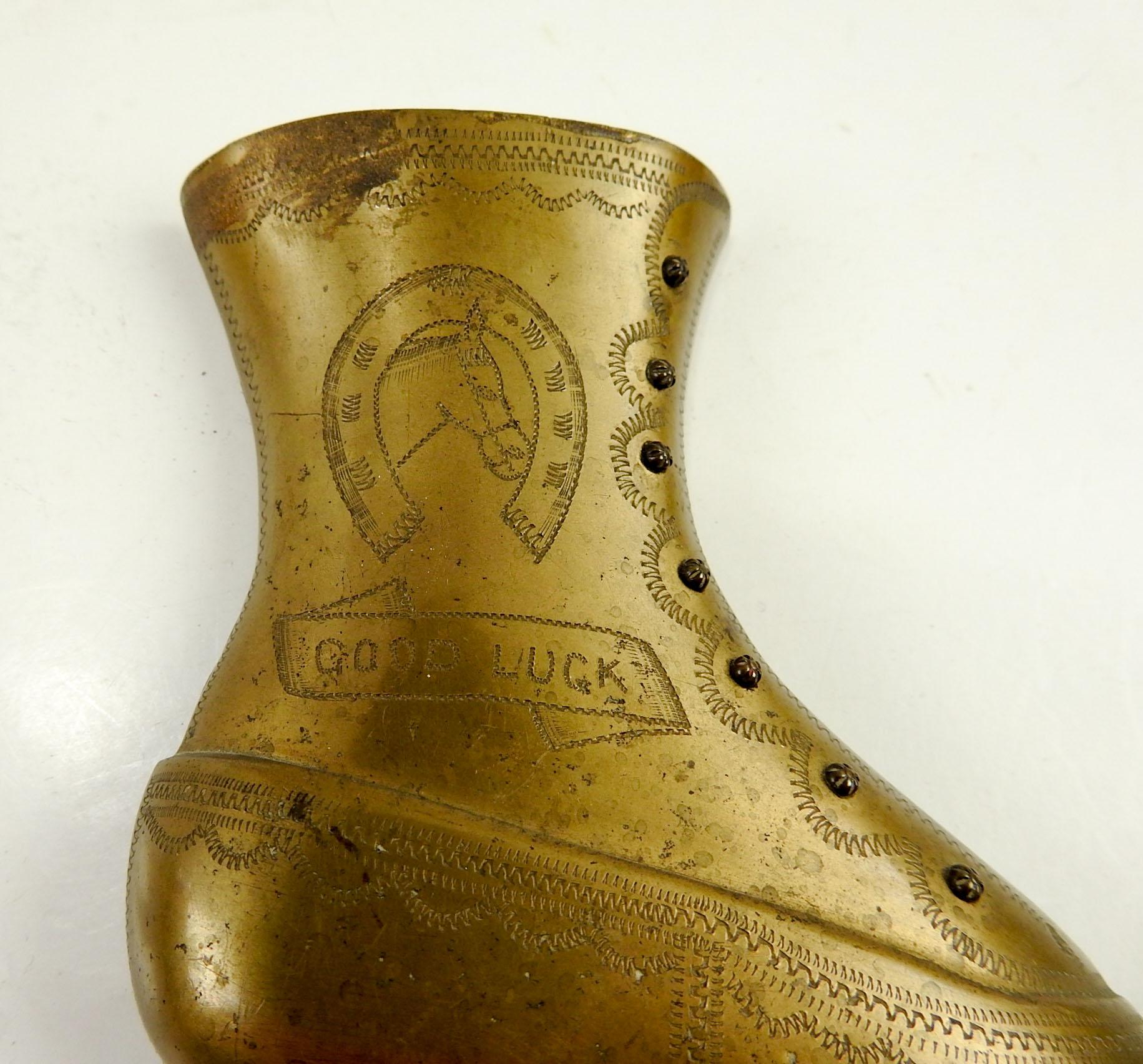 Circa 1900 brass bookends in the shape of a ladies button up shoe. Hand engraved decoration includes a horse, horse shoe and Good Luck. Overall patina, not polished.