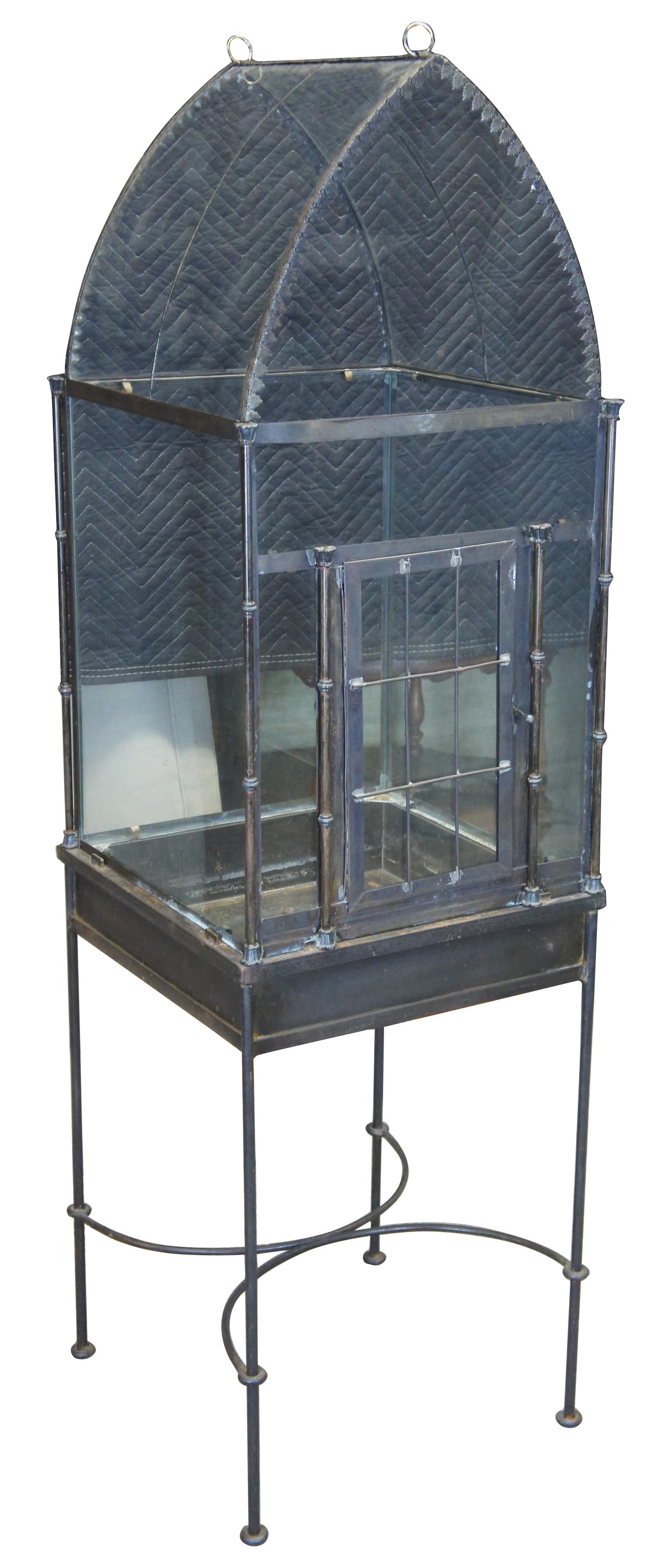 Victorian or Gothic inspired iron and glass terrarium on stand. Features dome top with door on front for access. Measures: 62”.
  