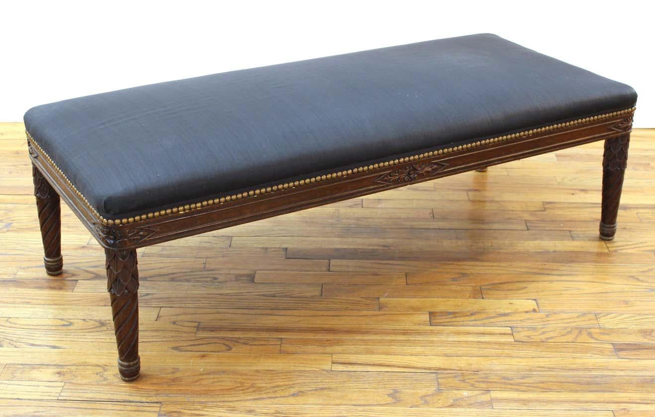Victorian Gothic Revival carved wood banquette ottoman with foliage motif and upholstery.