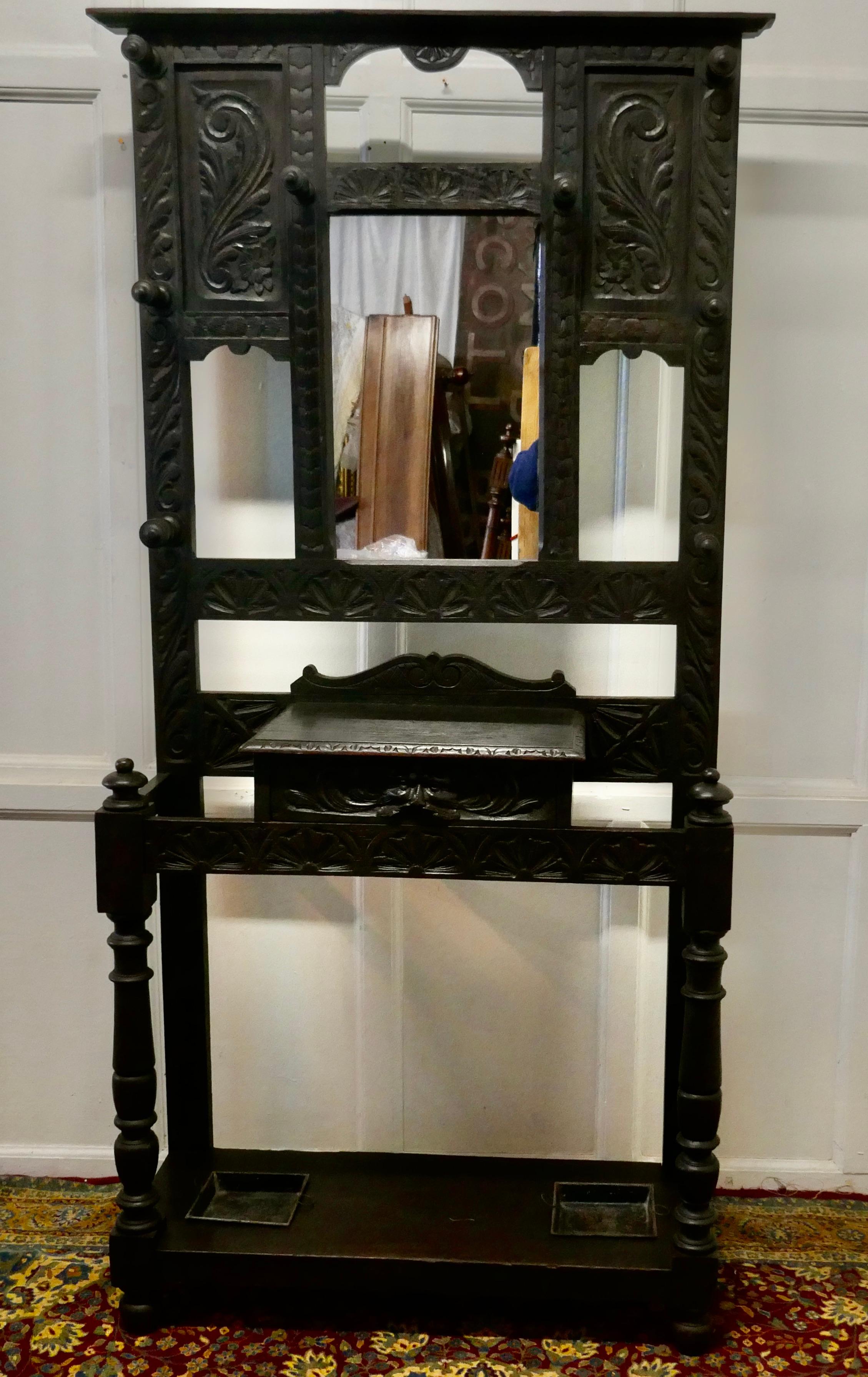 Victorian green man gothic carved oak hall stand 

This is a handsome piece, it is carved in oak, with 8 turned wooden coat hooks
The upper section has a mirror in the centre with carved panels on each side
The lower section has a glove drawer